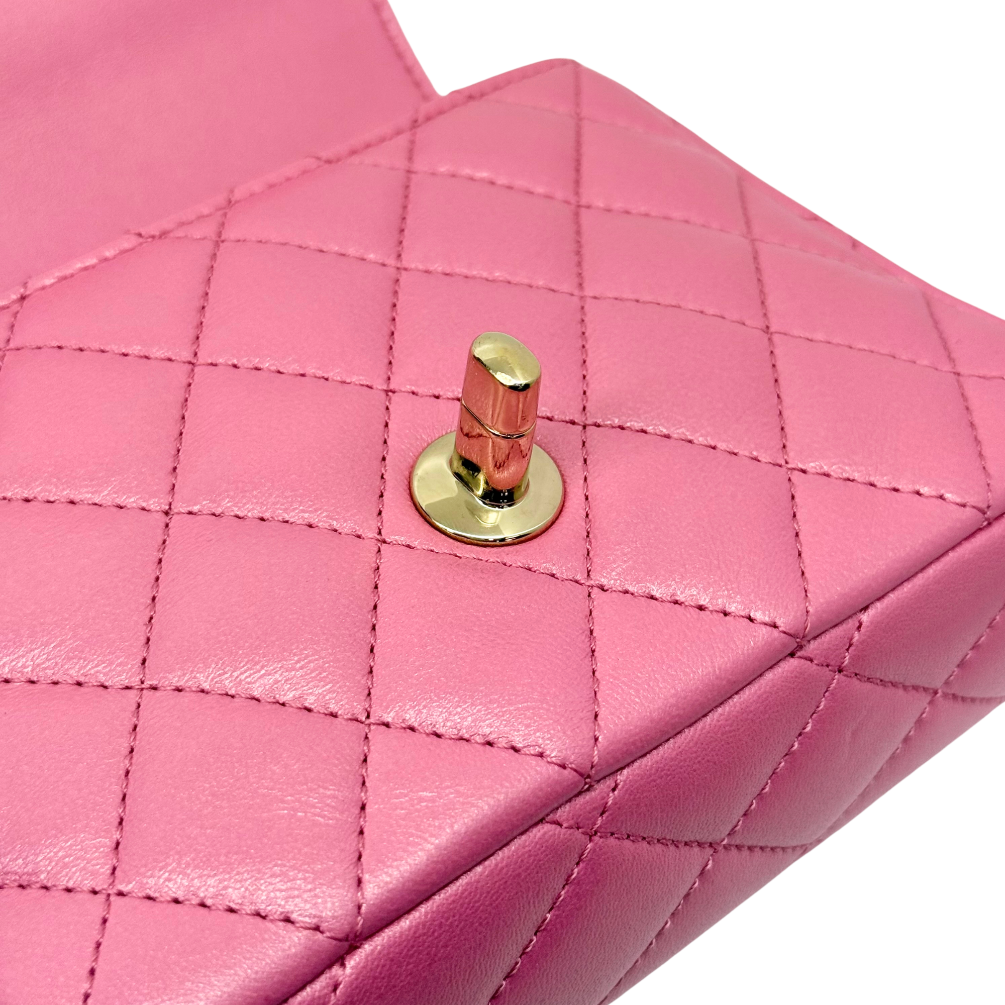 Gold turn-lock closure on pink quilted leather mini bag front