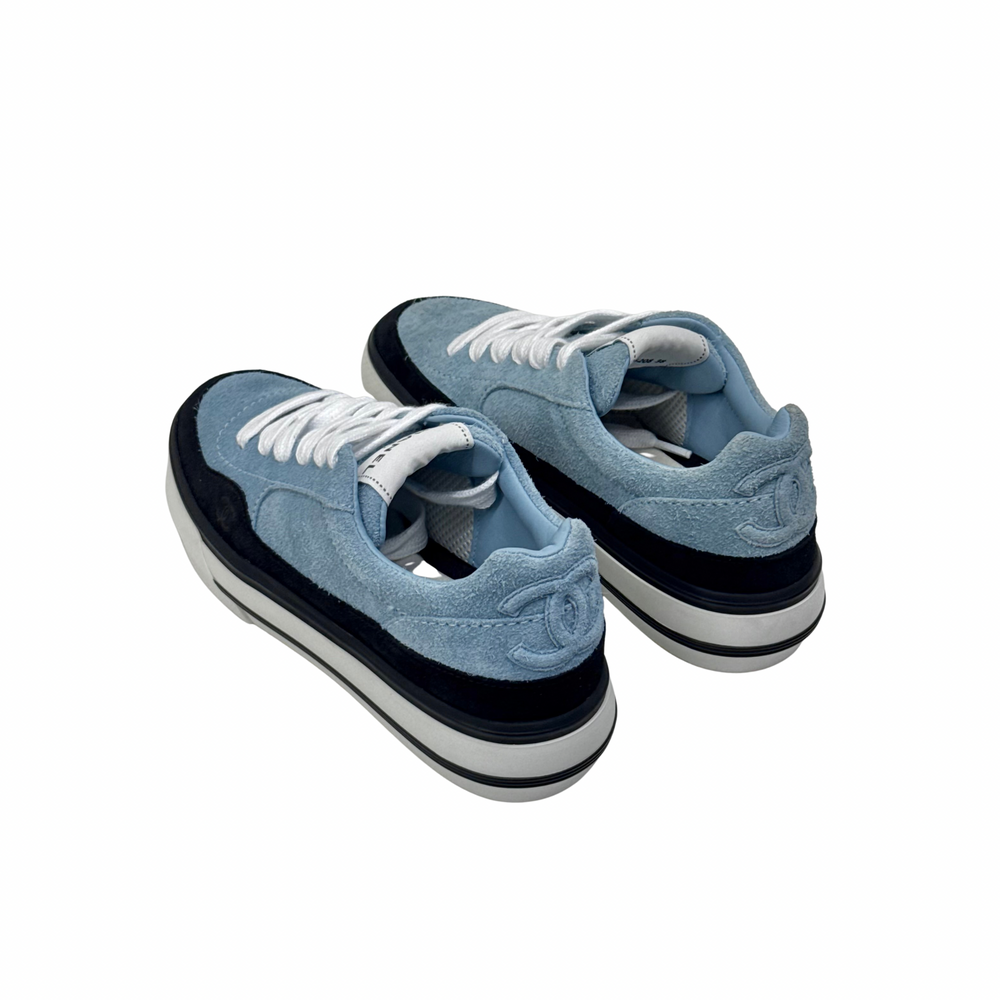 Blue suede sneakers with white laces and black sidewall, angled top view