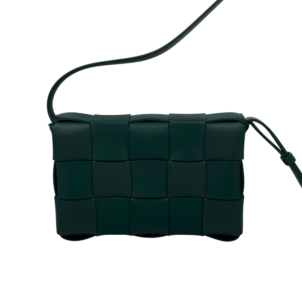 Green woven leather crossbody bag with top handle and strap loop