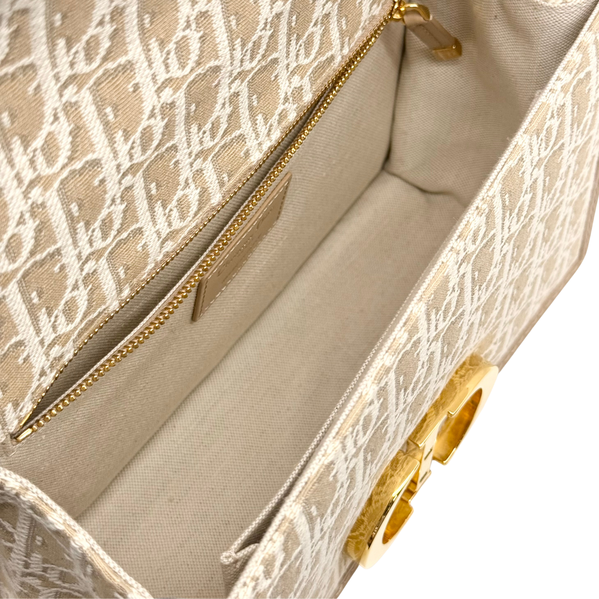 Dior pre-owned bag showing zipper pocket and beige interior with gold hardware