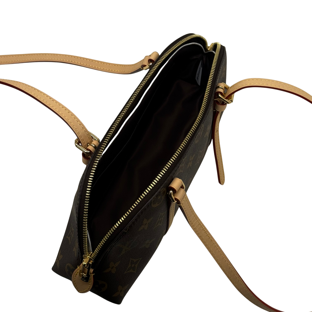 Monogram crossbody bag with top zipper, tan strap, and hanging key charm