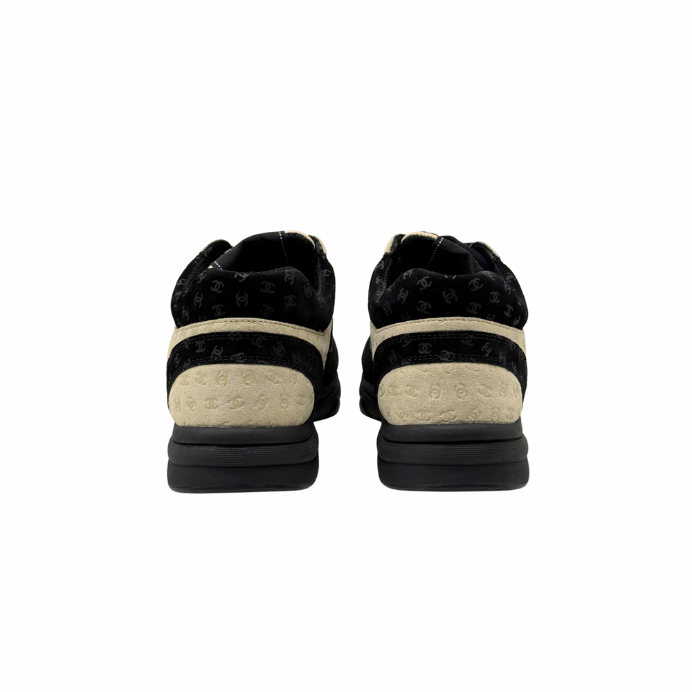 Black and beige Chanel sneakers, back view showing rear counter and rubber sole