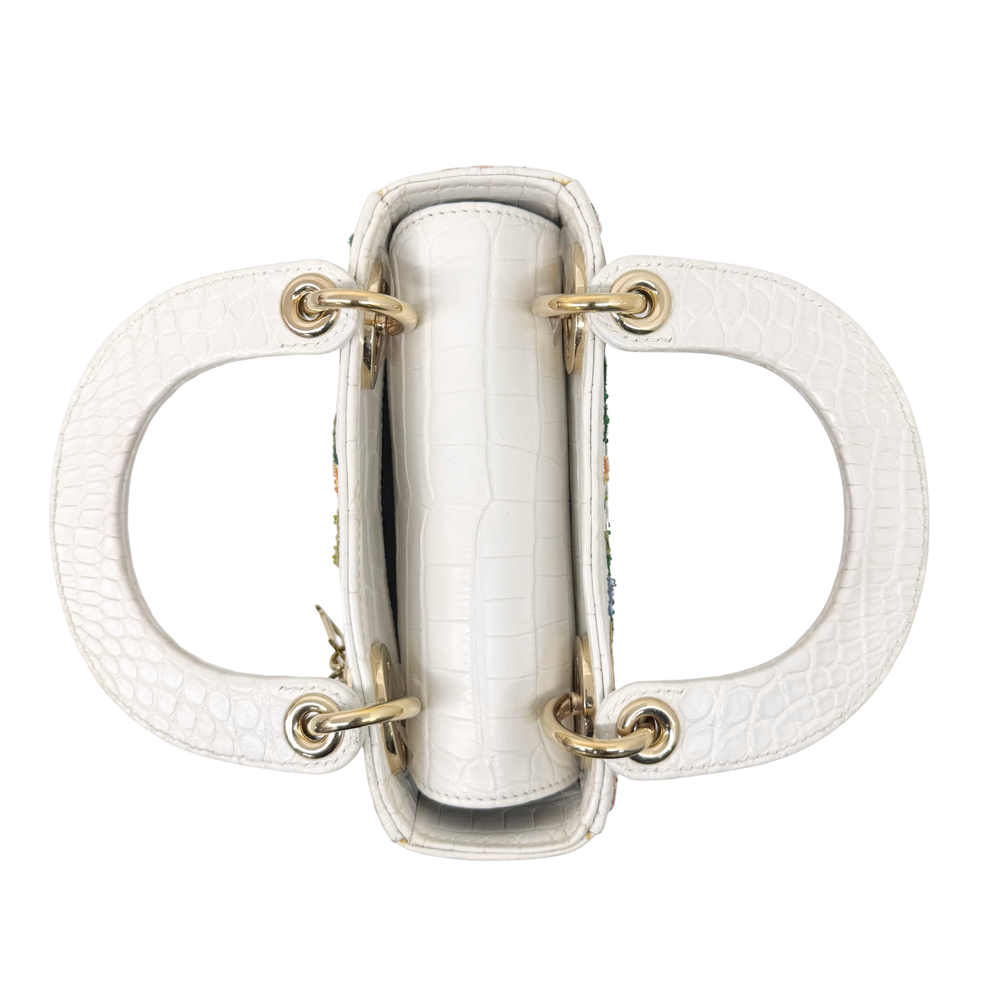 White leather mini handbag top view with double handles and gold hardware