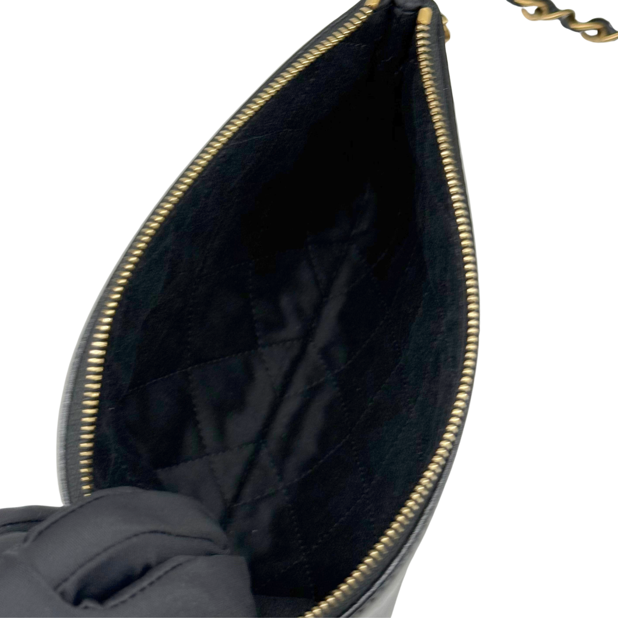 Black quilted leather shoulder bag interior, visible lining and gold-tone zipper trim
