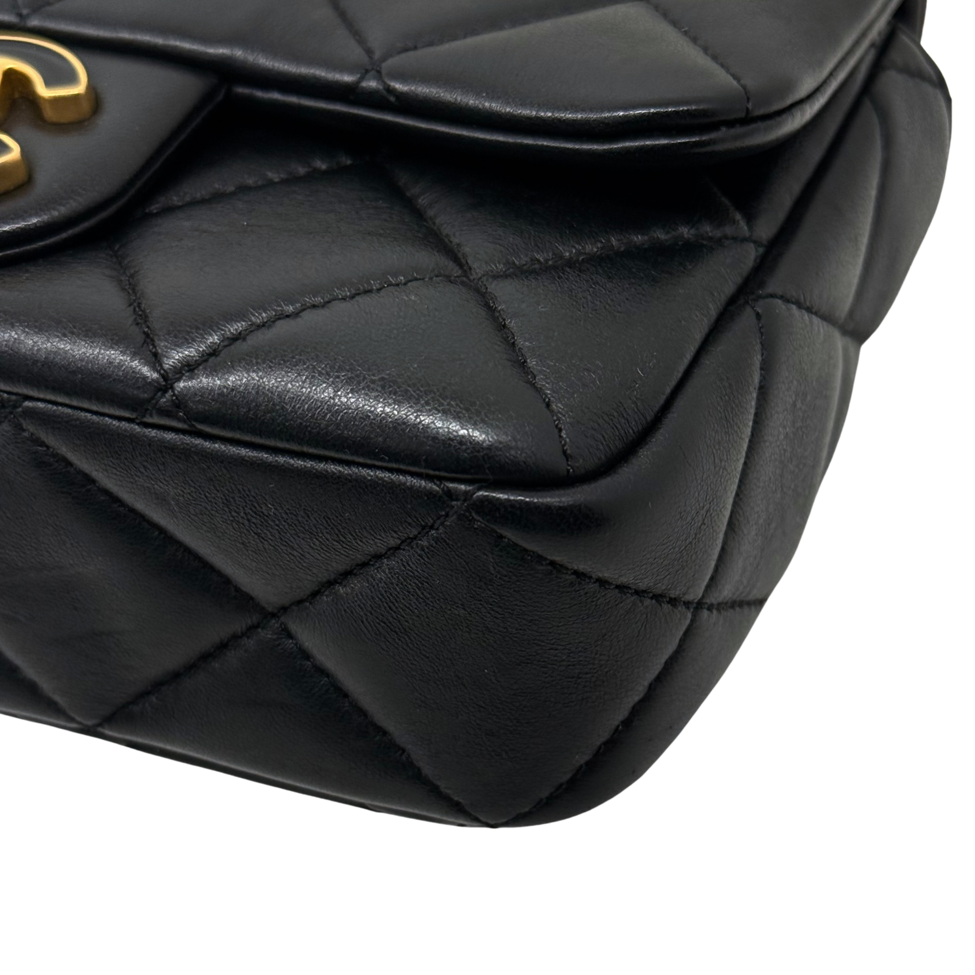 Black quilted leather bag corner detail with stitched diamond panels