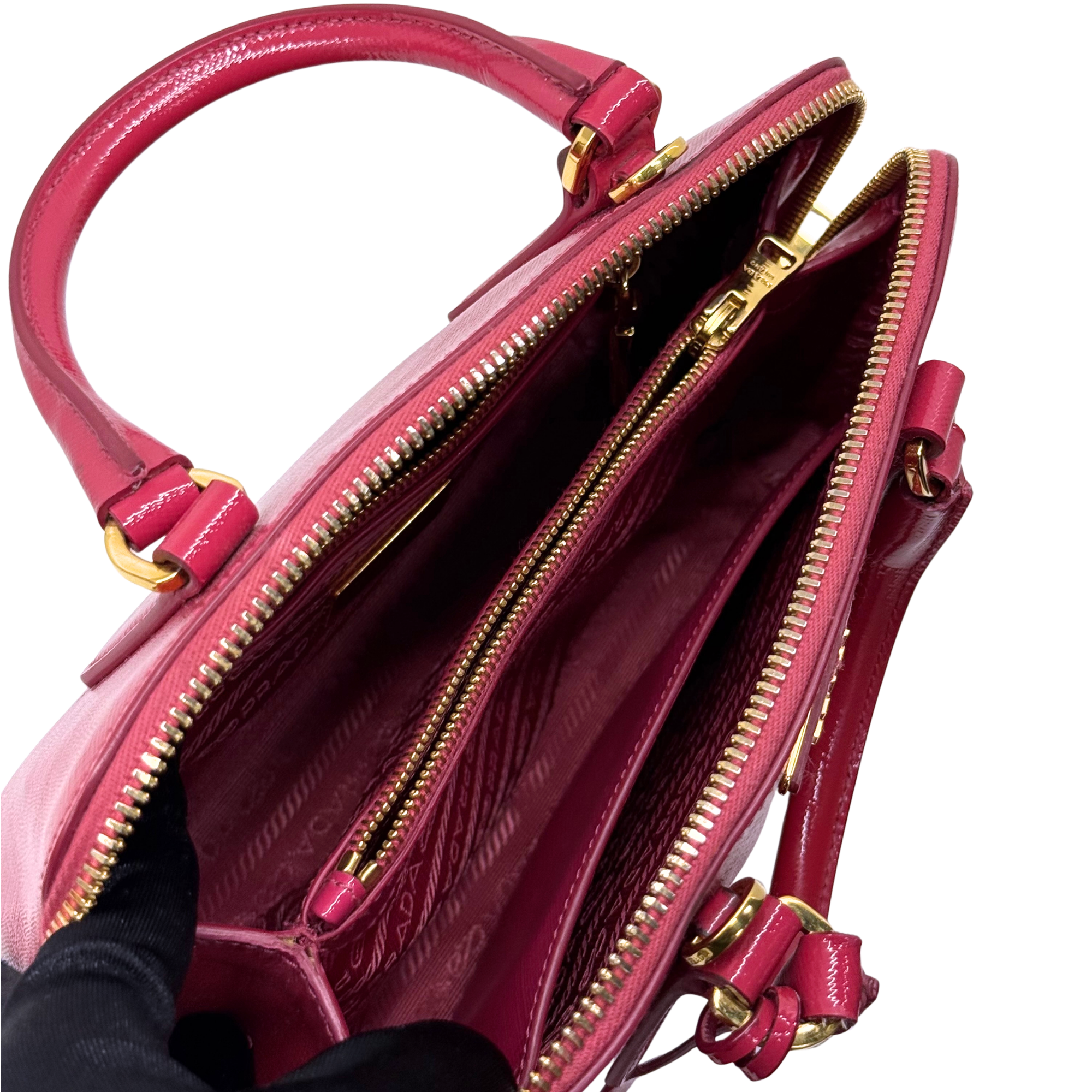 Prada pink handbag interior view with two zip pockets and gold zipper pulls