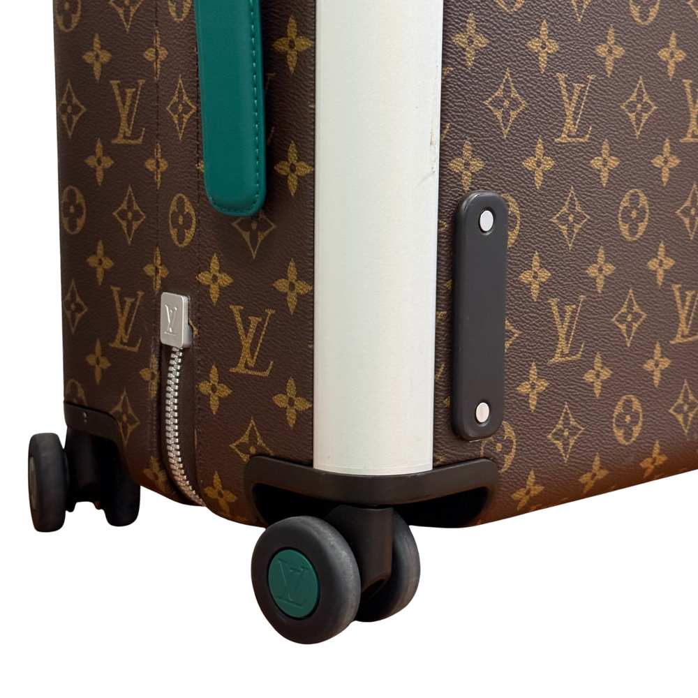 Pre-owned rolling suitcase corner detail, monogram body, teal tab, and wheel base