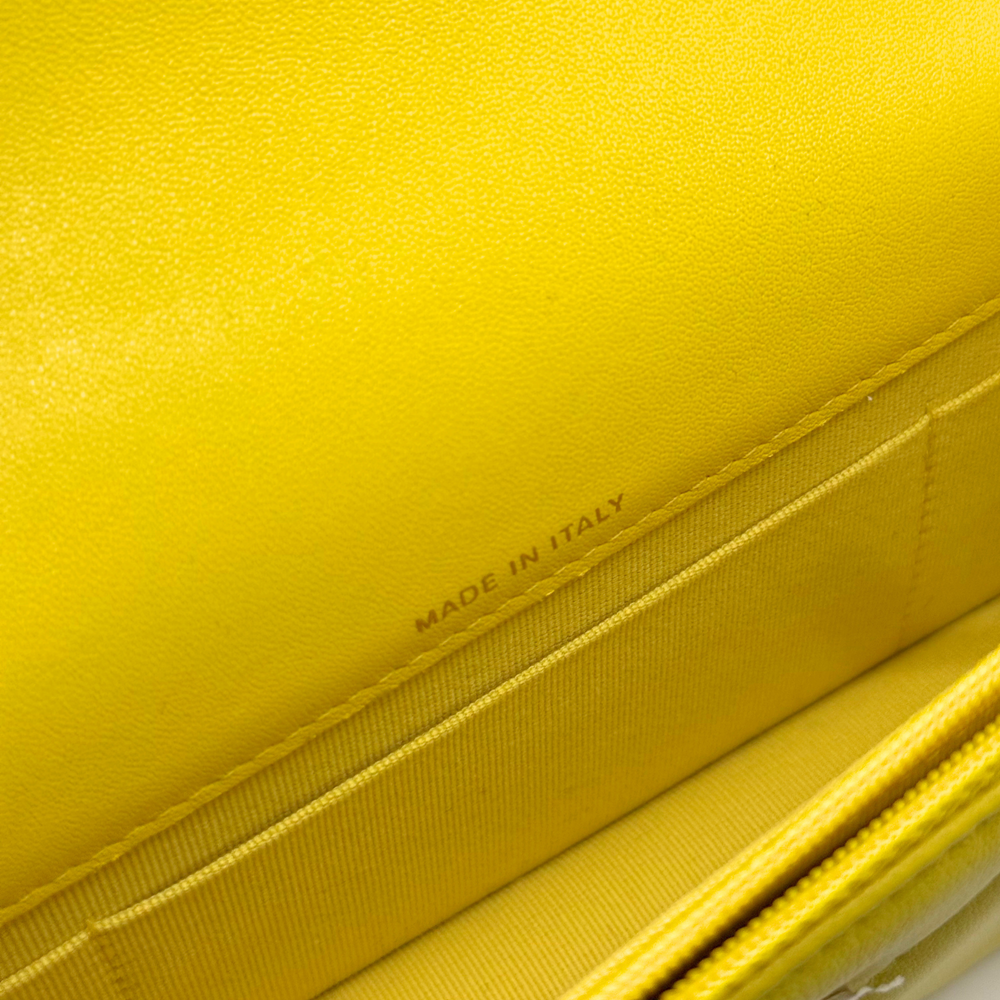 Yellow leather quilted bag corner detail with stitching and seam
