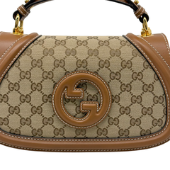 Monogram canvas shoulder bag front with gold-tone logo emblem