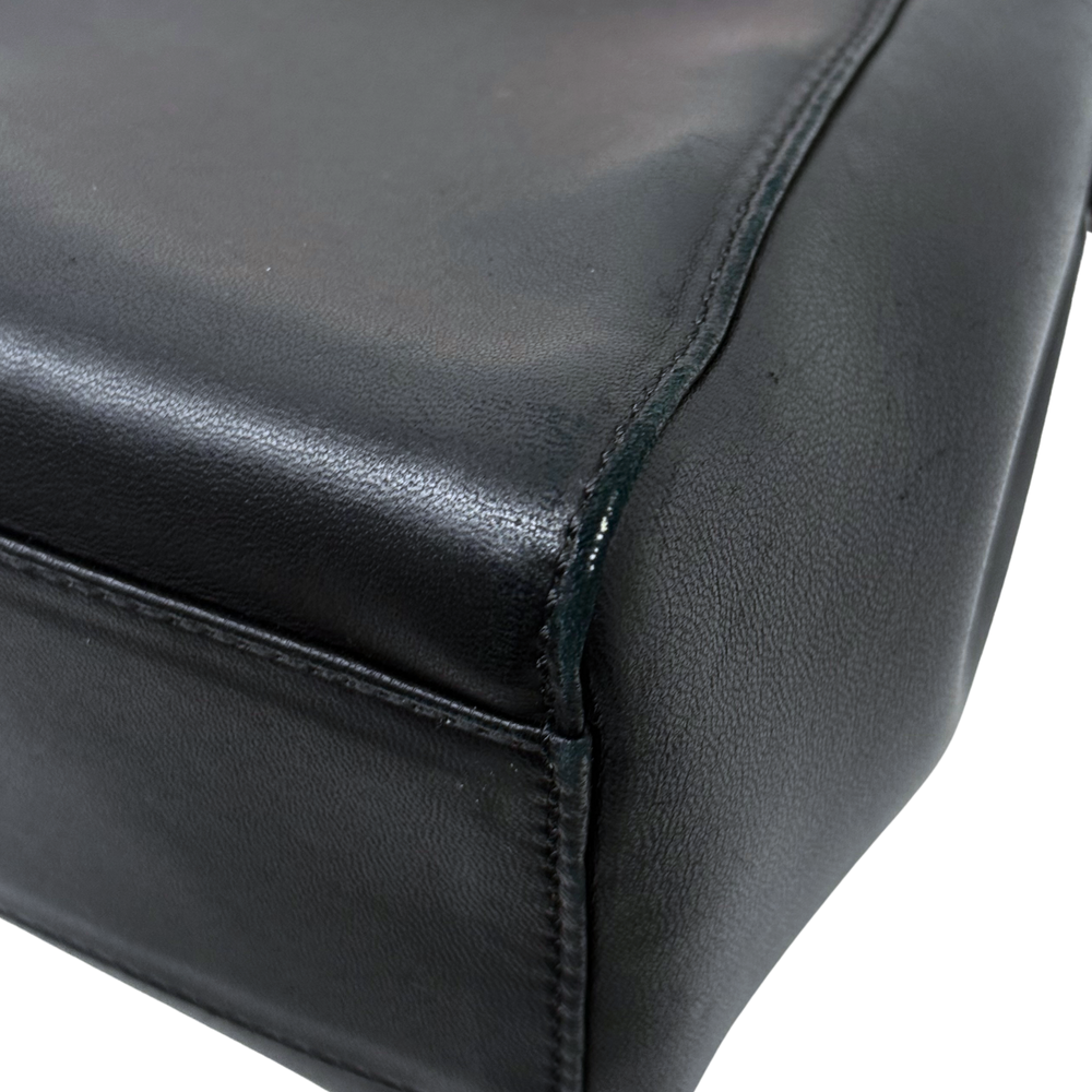 Close-up of black leather handbag side seam and stitching