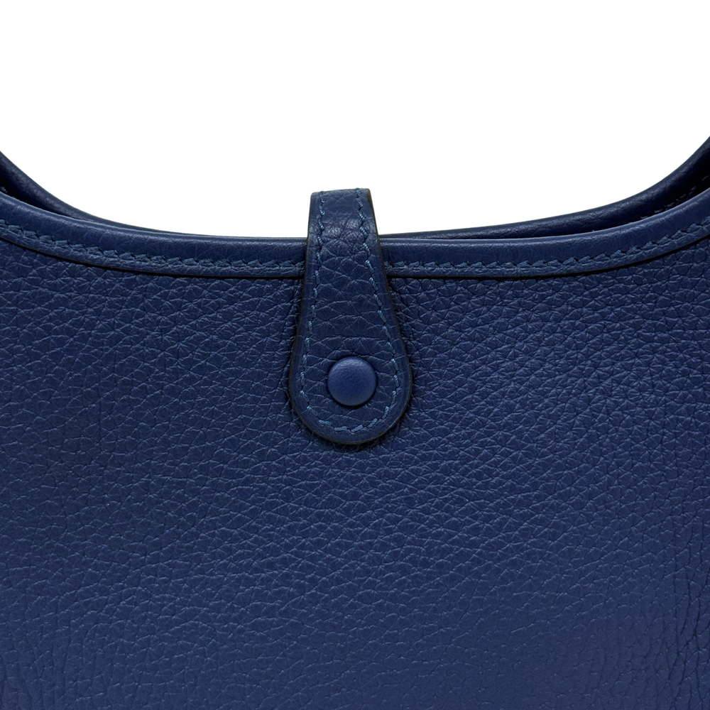 Navy blue leather crossbody bag close-up of centered snap tab