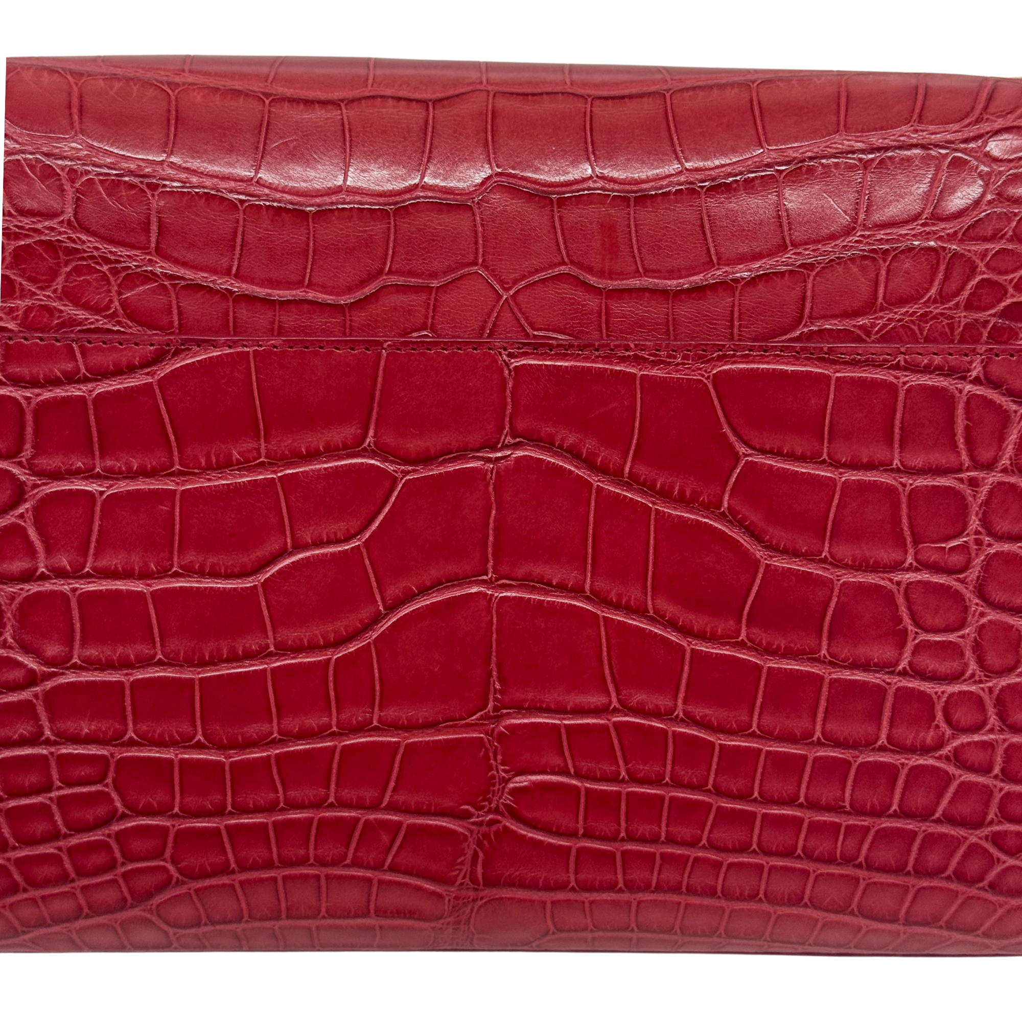 Red crocodile-embossed leather panel with textured scale pattern on the flap