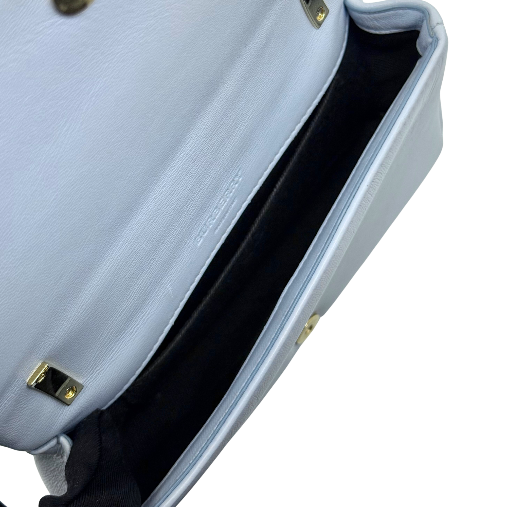 Light blue leather shoulder bag interior opening with gold hardware side detail.