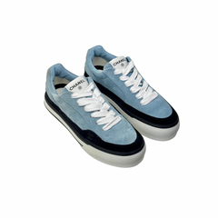 Two blue suede sneakers with white laces and black sidewall, angled view