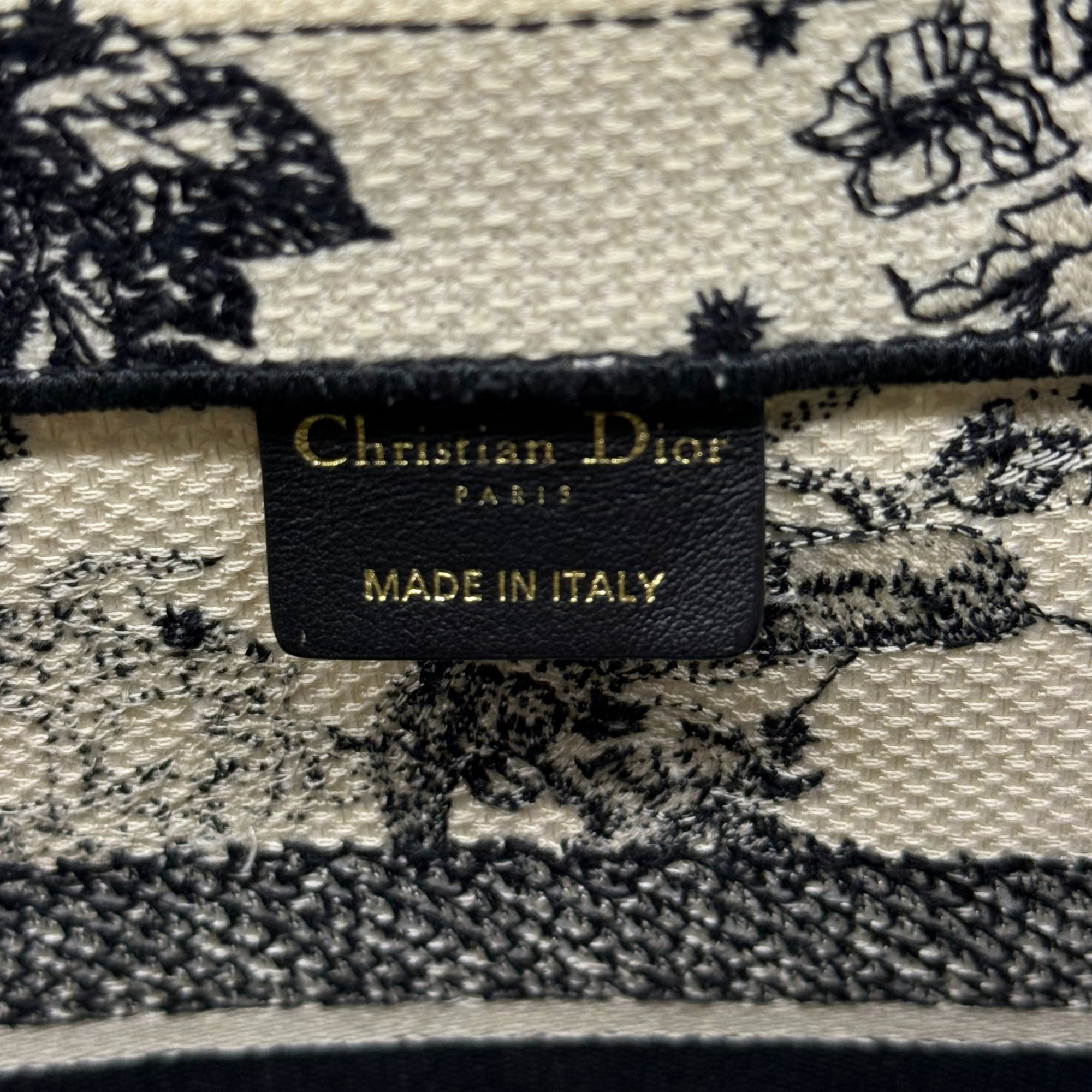 Dior canvas tote bag interior label reading Christian Dior and Made in Italy