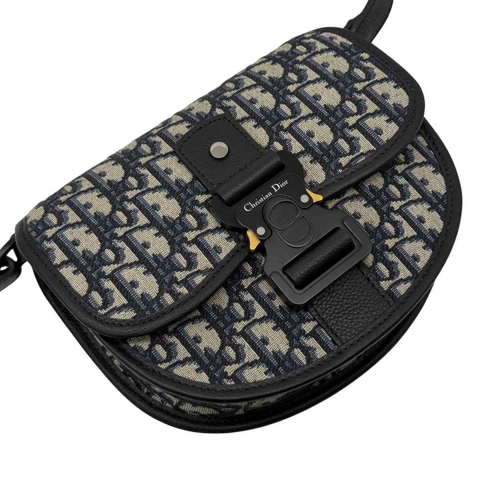Dior crossbody bag with adjustable strap and front clasp on patterned canvas