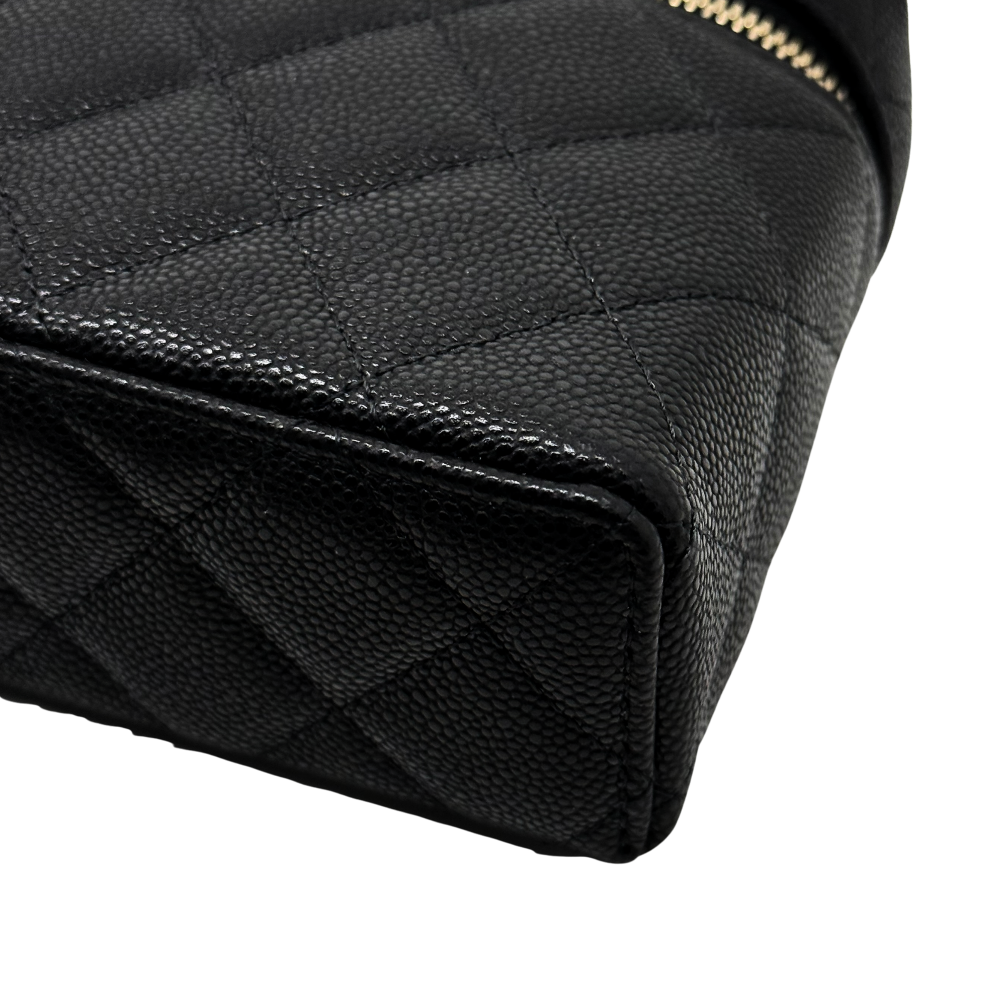 Black quilted Chanel leather bag corner with stitched texture and zip edge