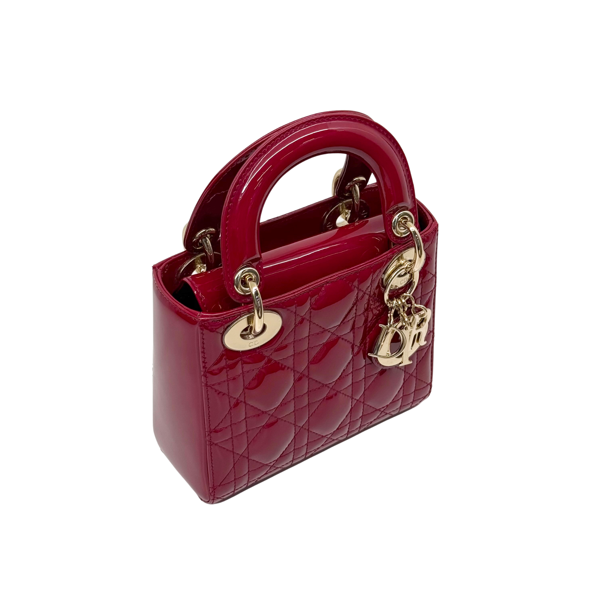Red quilted patent leather mini handbag with top handle and gold D charm on side