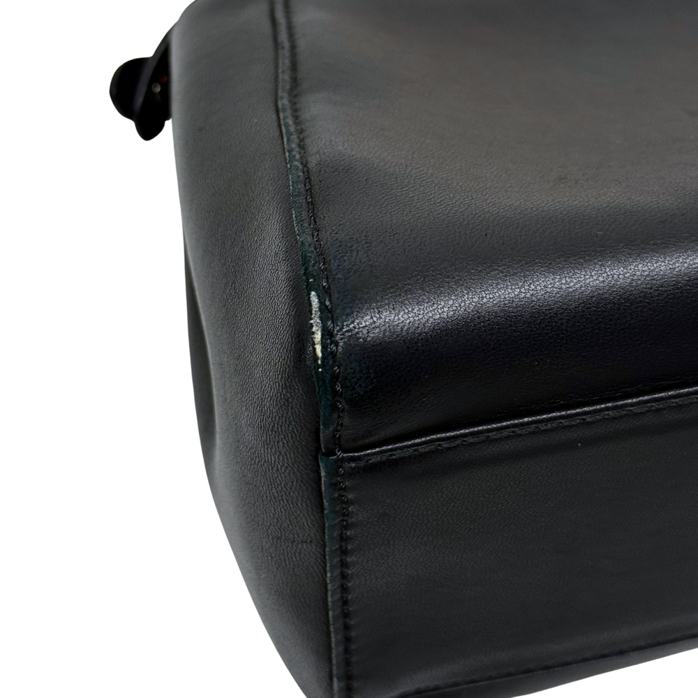 Close-up of black leather handbag corner with visible stitching
