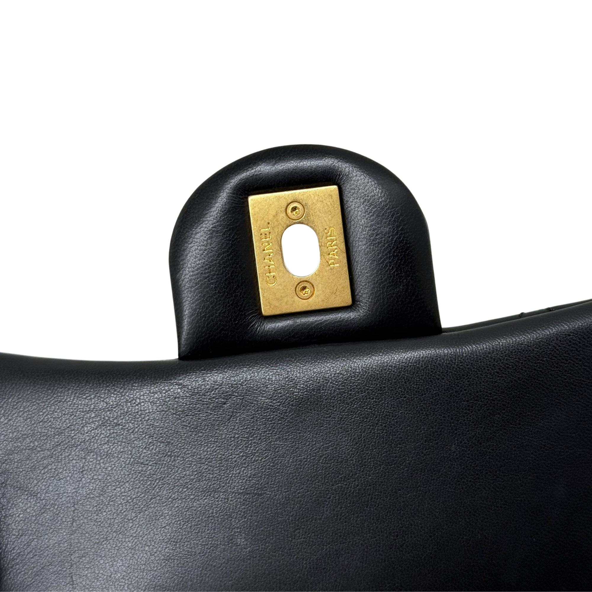 Black leather bag flap with square gold-tone logo plate and keyhole opening