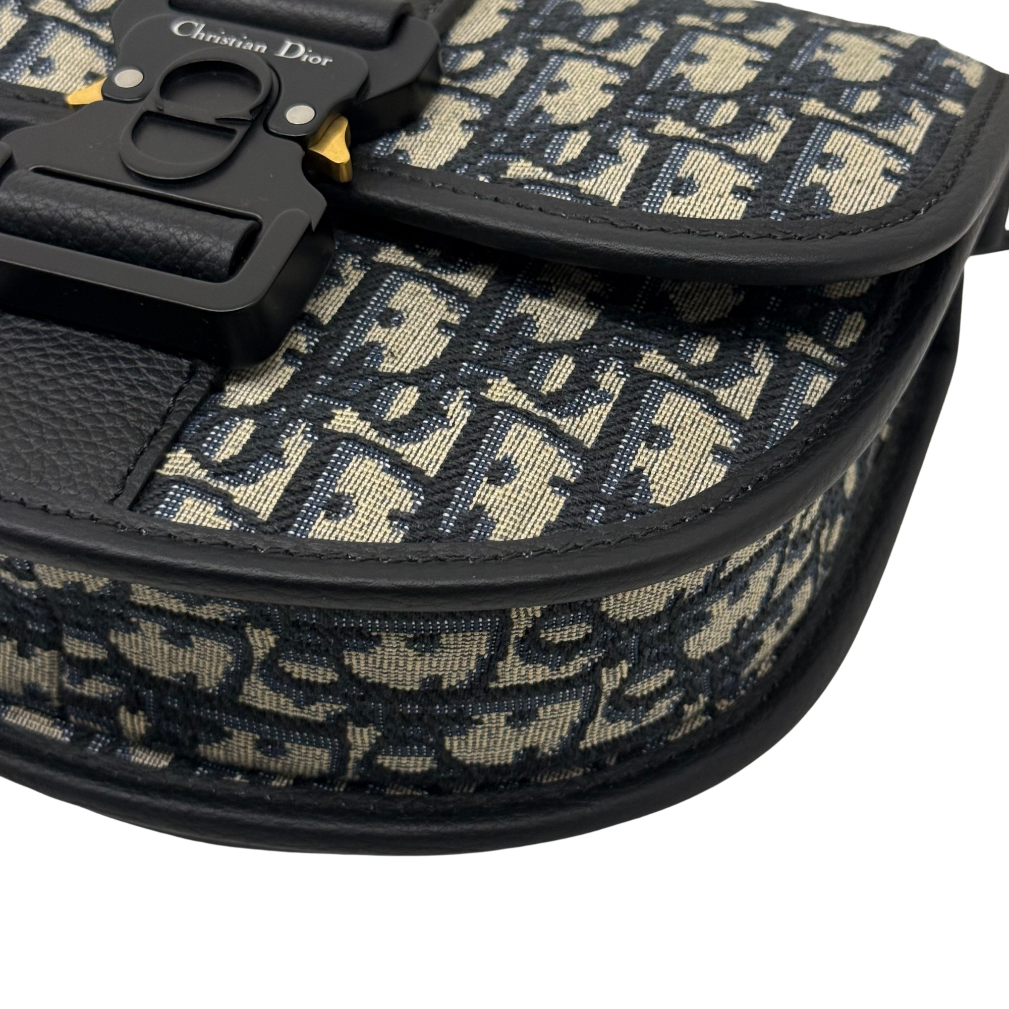 Curved black-trimmed flap edge on Dior patterned canvas crossbody bag
