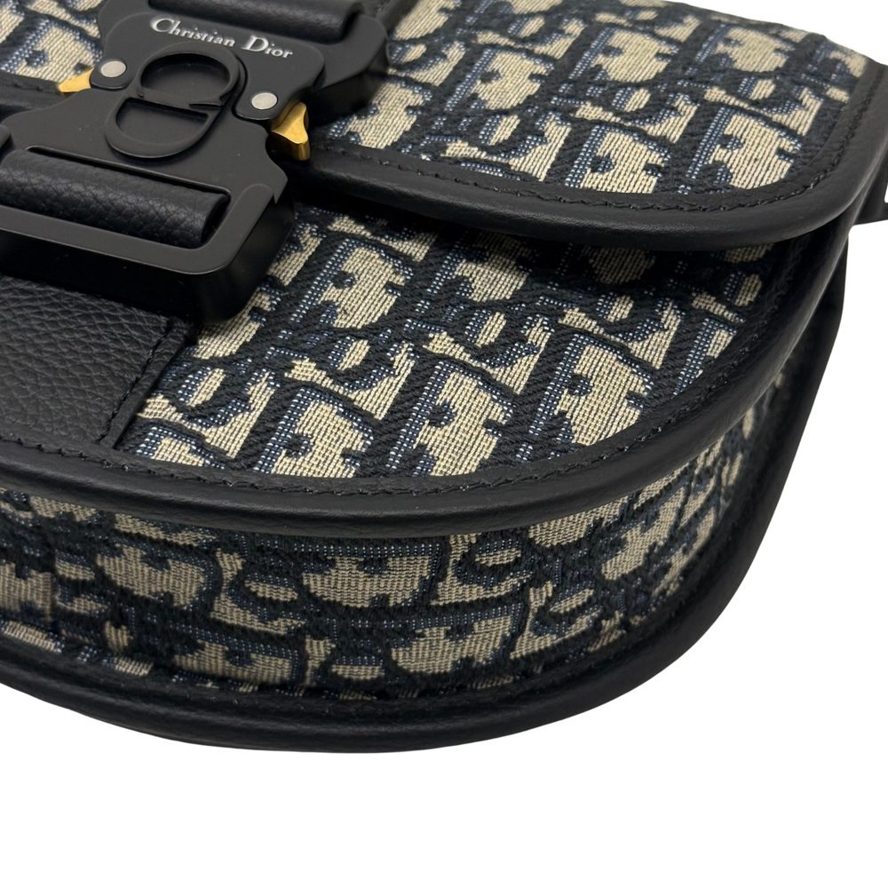 Curved black-trimmed flap edge on Dior patterned canvas crossbody bag
