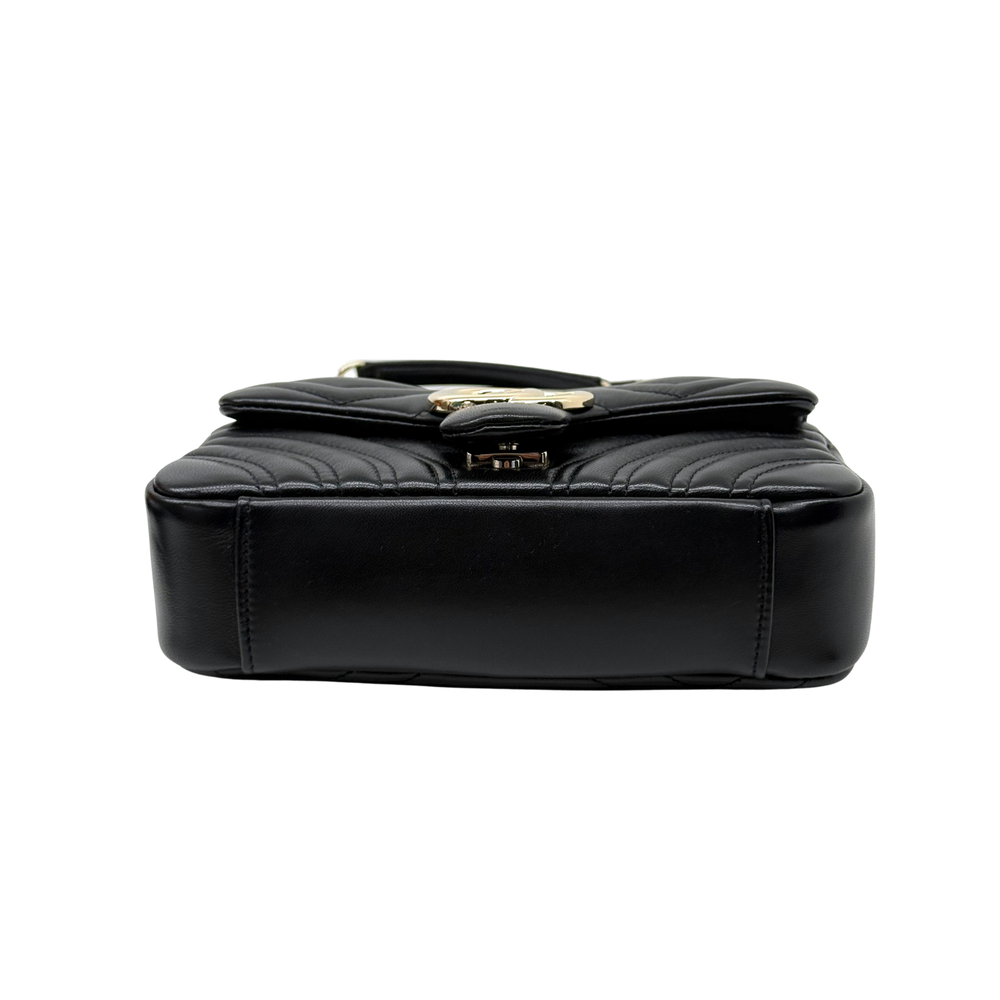 Gucci shoulder bag top view with black quilted leather flap and gold clasp