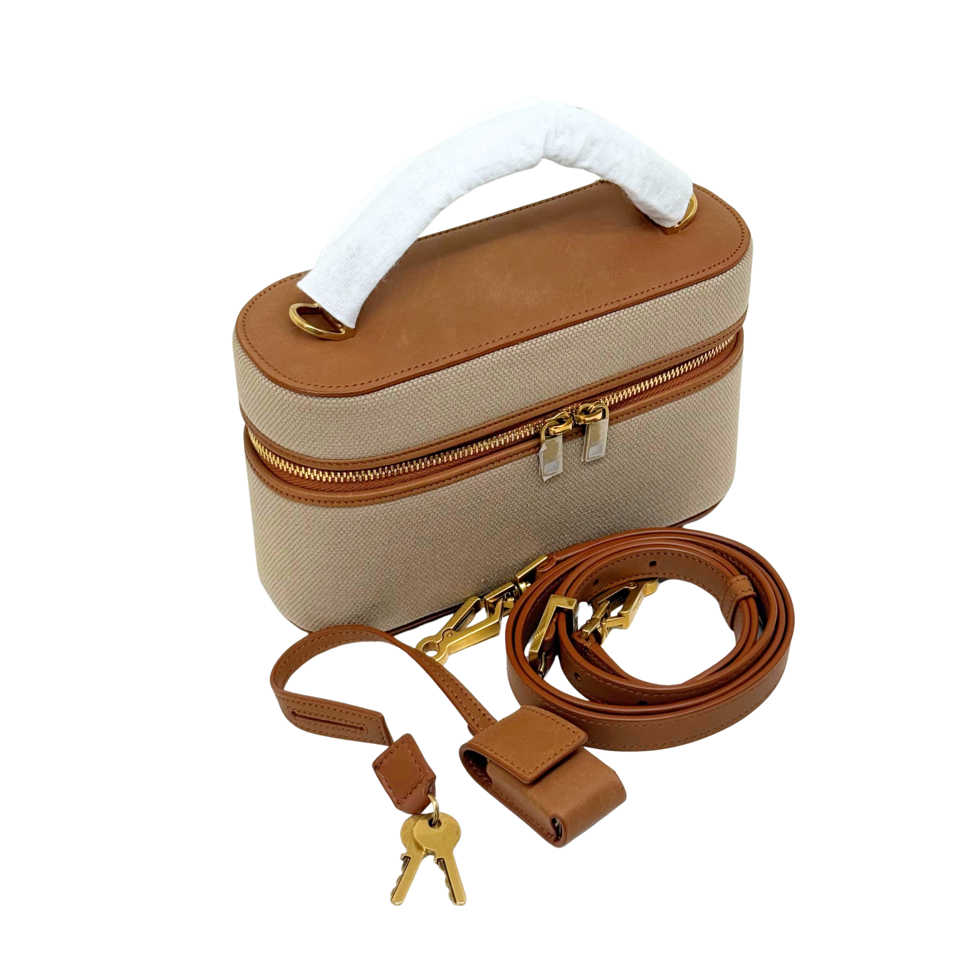 Beige vanity bag with brown leather trim, top handle, and gold zip closure