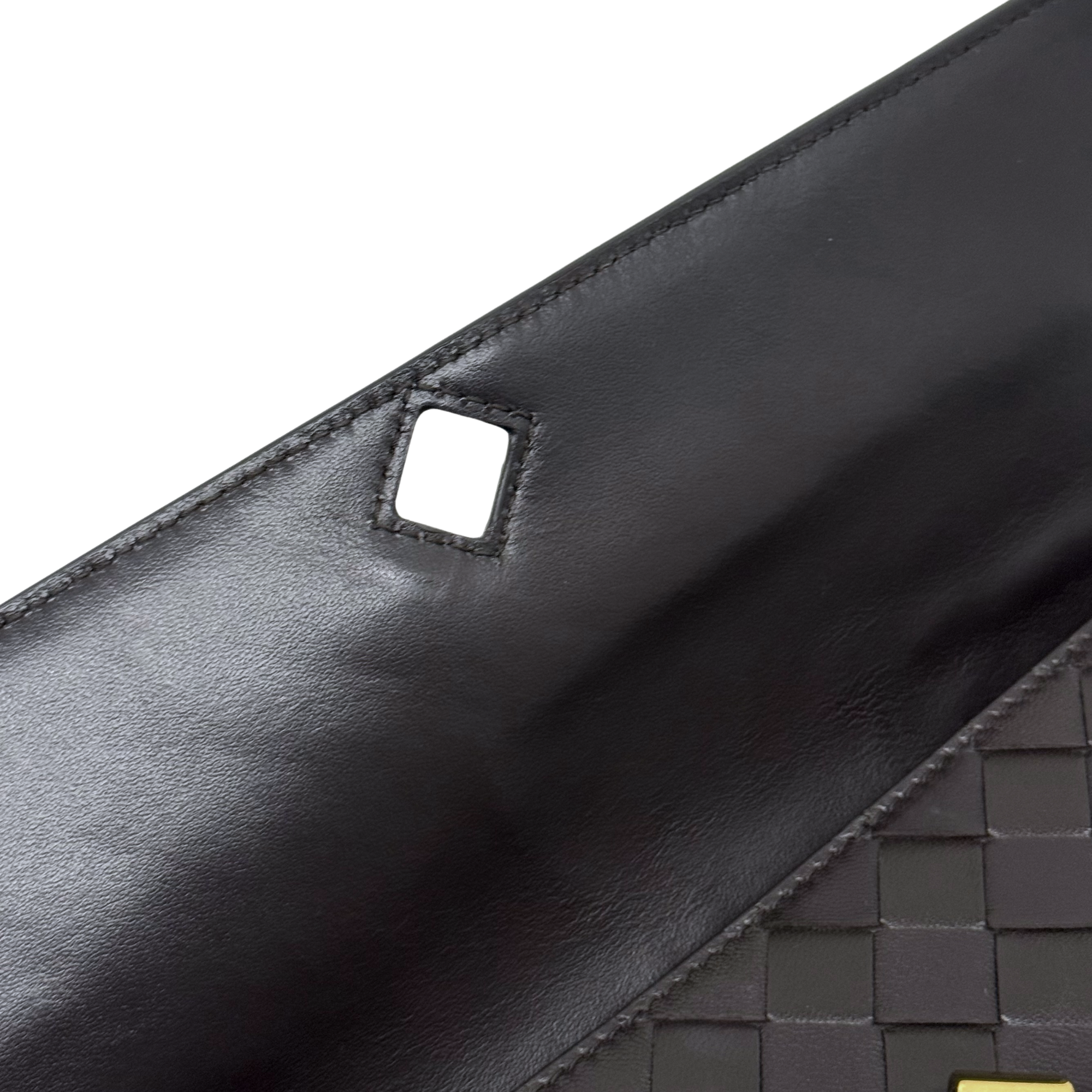 Black leather strap tab with square cutout detail on woven panel