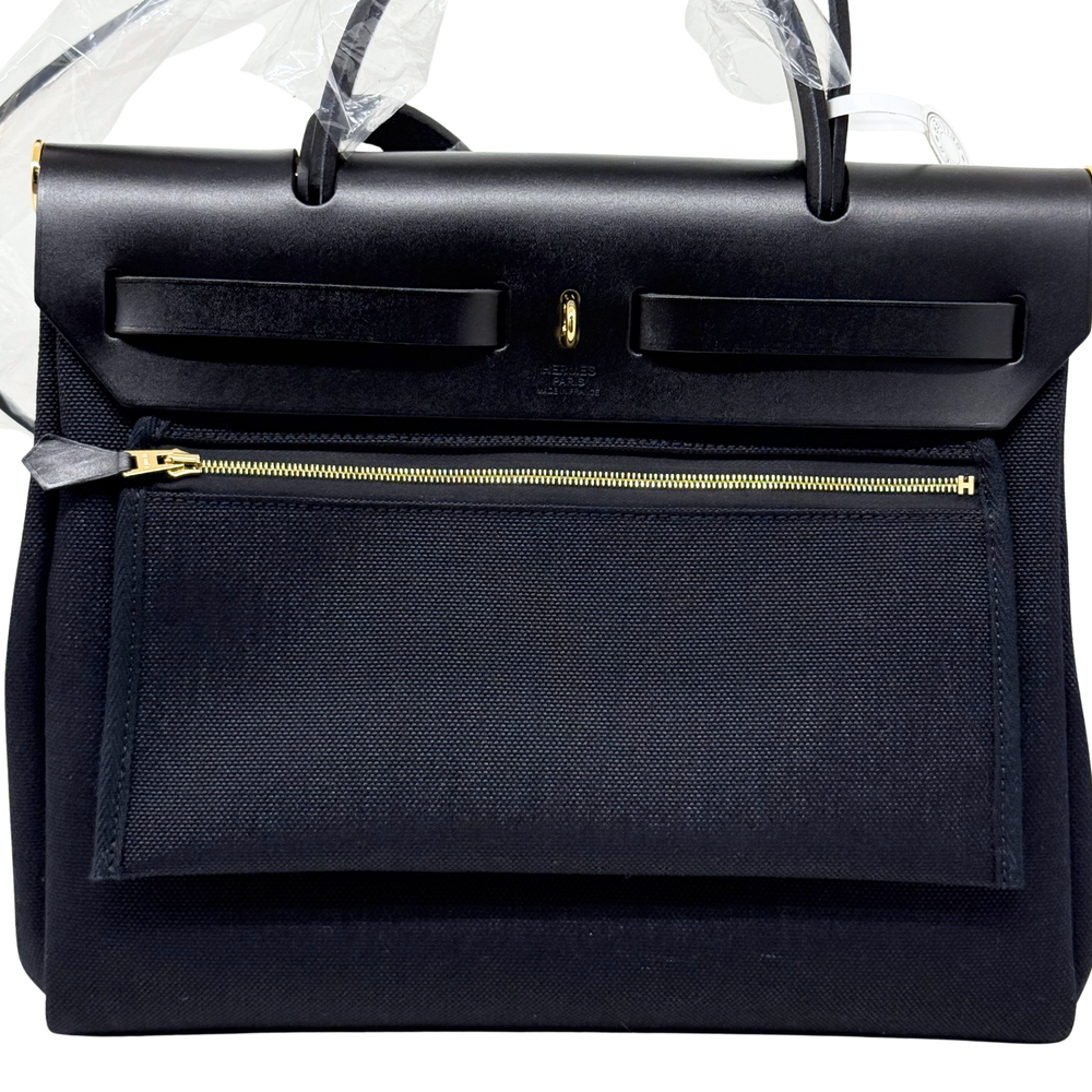 Hermes black leather handbag with front flap and gold-tone zipper pocket
