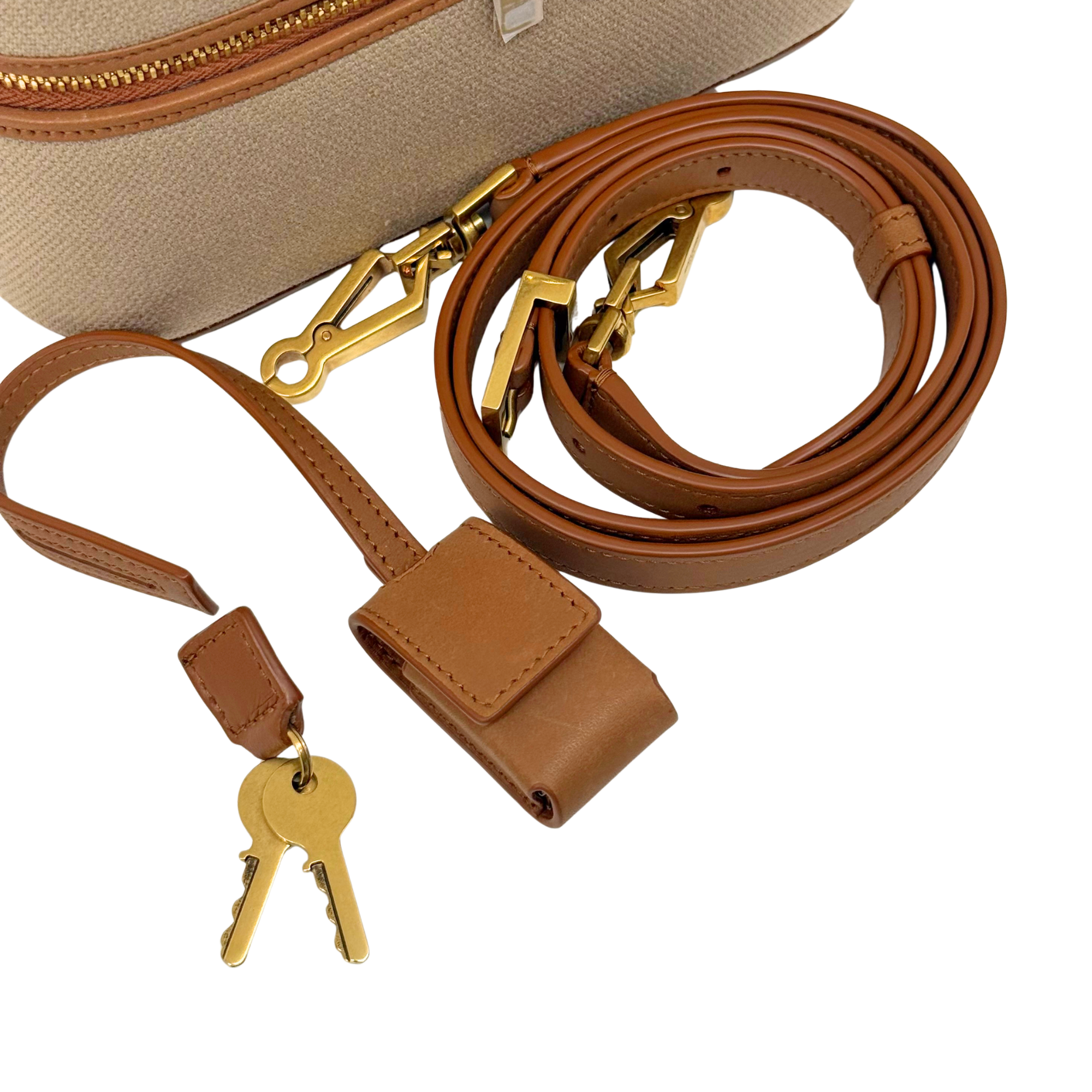Beige vanity bag with brown leather strap, gold zipper pull, and key holders