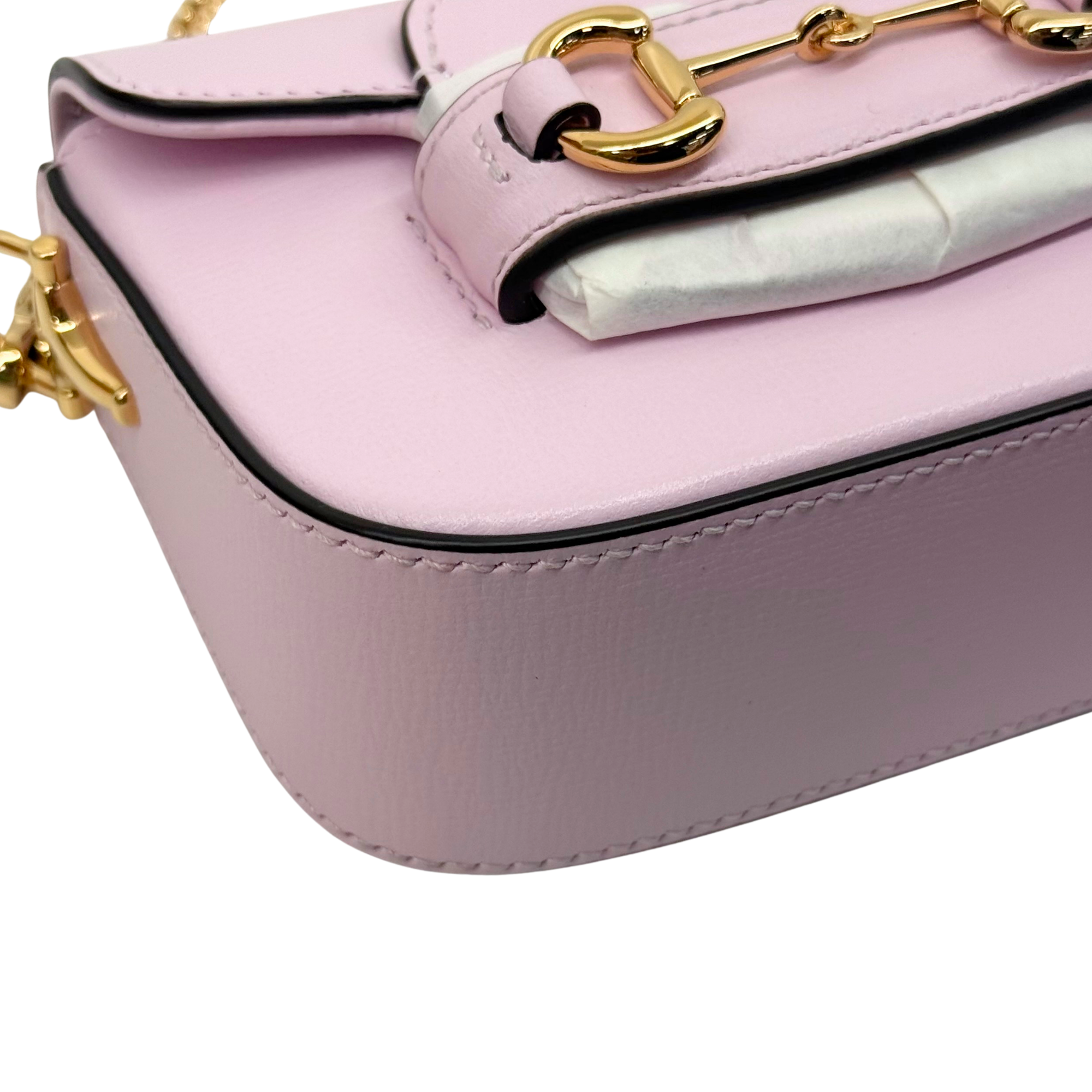 Pink Gucci mini bag close-up: gold buckle clasp and chain strap detail