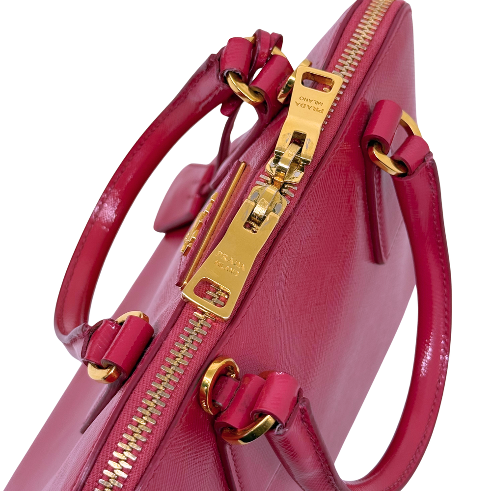 Prada pink handbag close-up of zipper hardware and top handle attachment rings