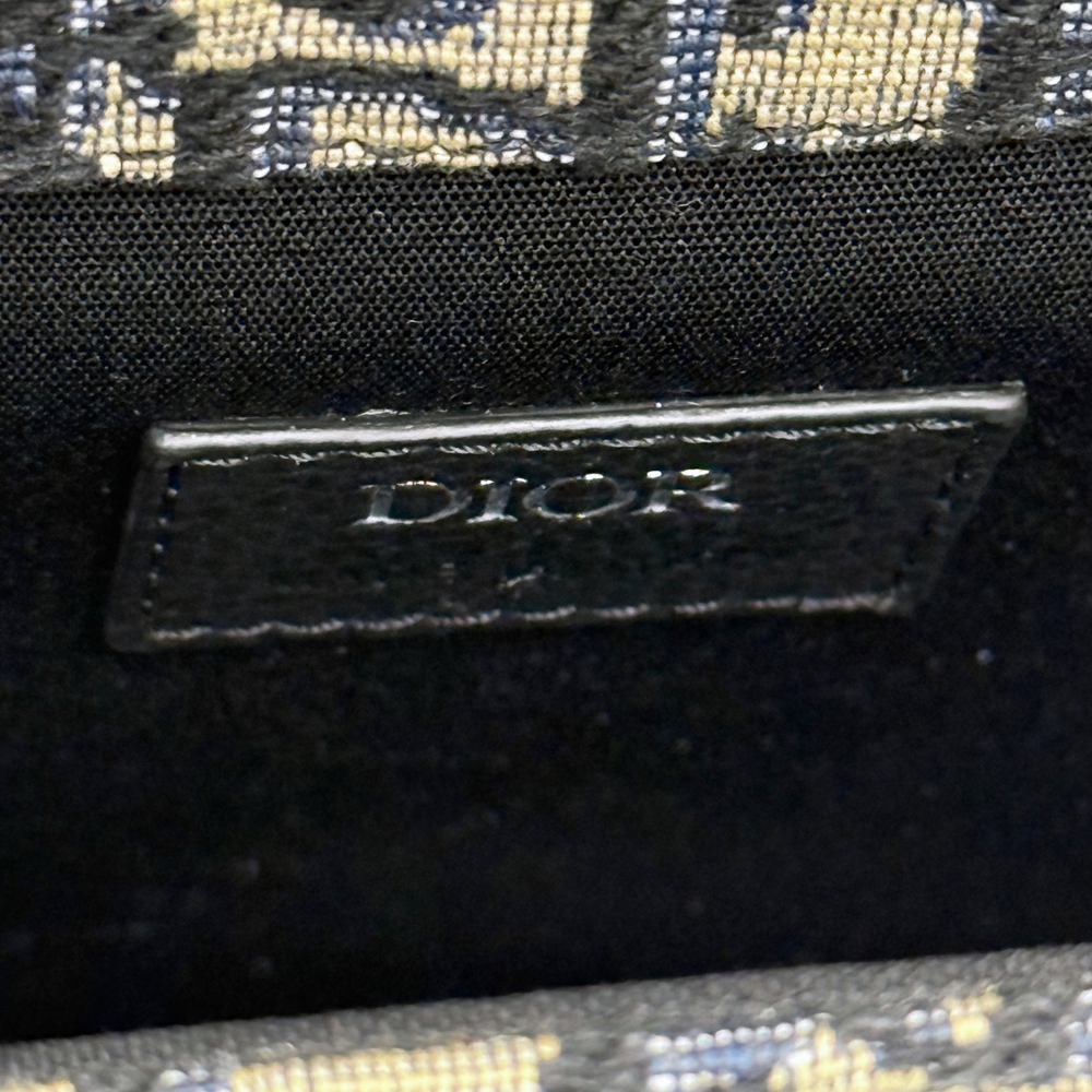Black leather Dior brand tag on patterned canvas crossbody bag