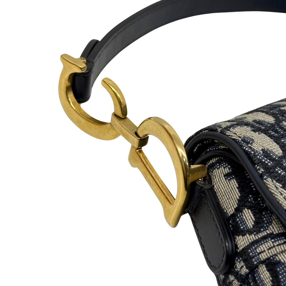 Pre-owned Dior saddle bag close-up of gold D-ring and black strap hardware