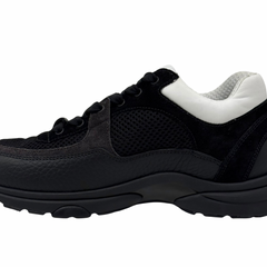 Black and white low-top sneakers with mesh panels, padded collar, thick tread sole.