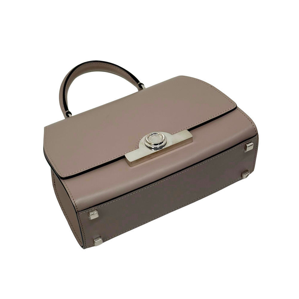 Moynat taupe leather handbag side view with front clasp bar and silver feet