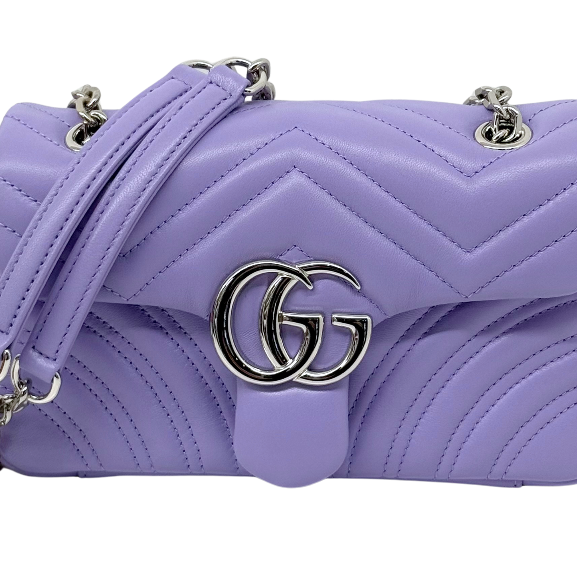 Lavender quilted bag close-up with GG metal logo and chevron stitching