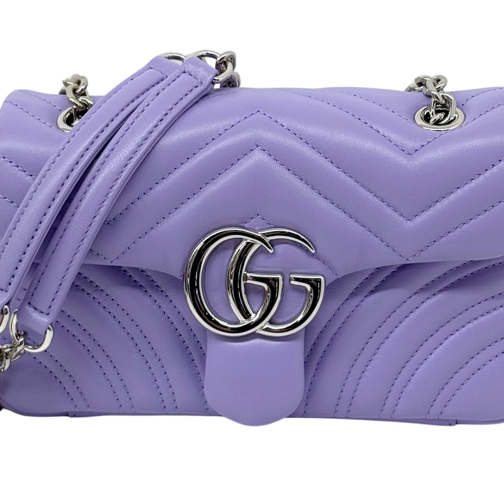 Lavender quilted bag close-up with GG metal logo and chevron stitching