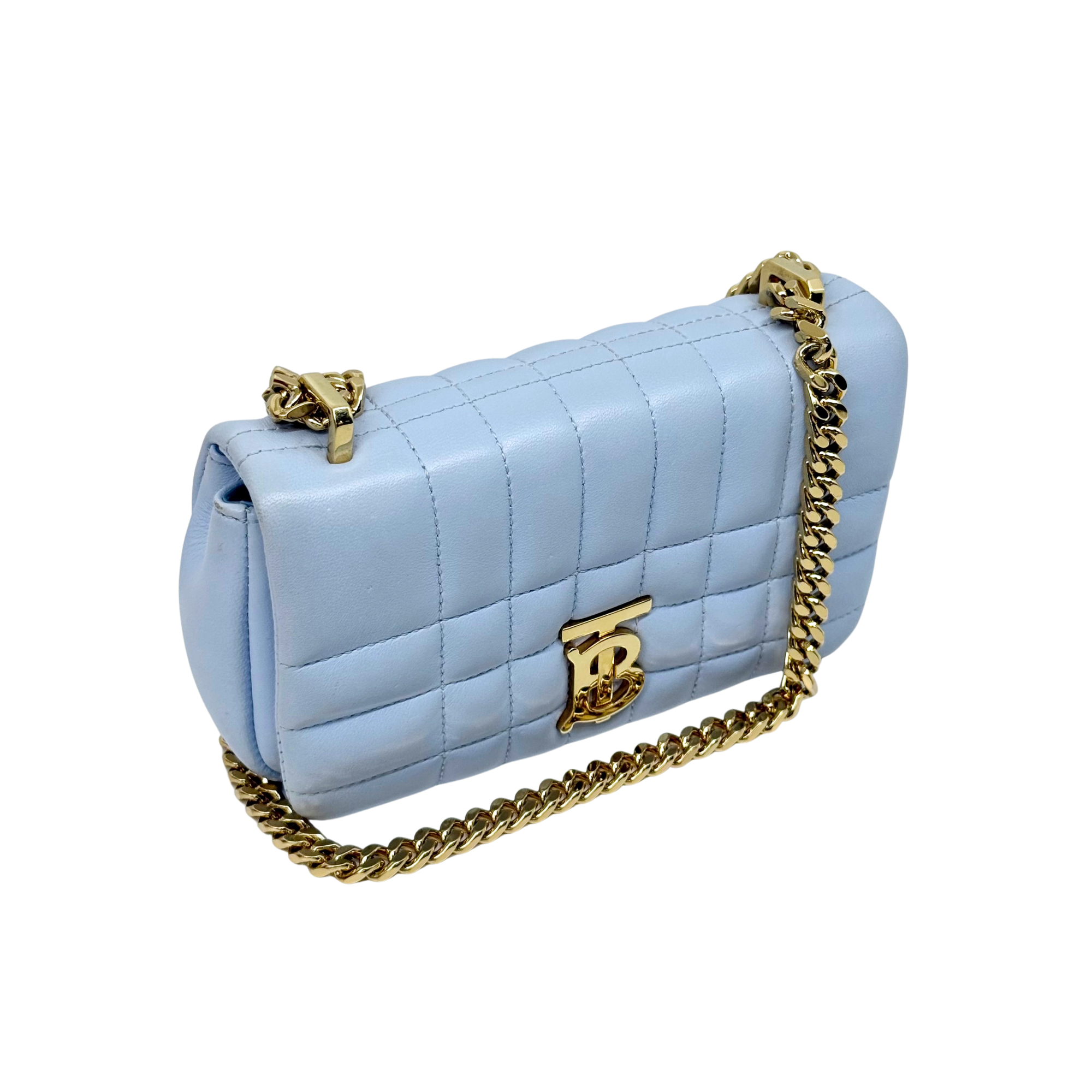 Light blue quilted shoulder bag with gold chain strap and front B logo plaque.