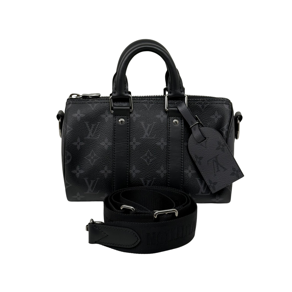 Black monogram handbag with top handles, zip closure, and crossbody strap