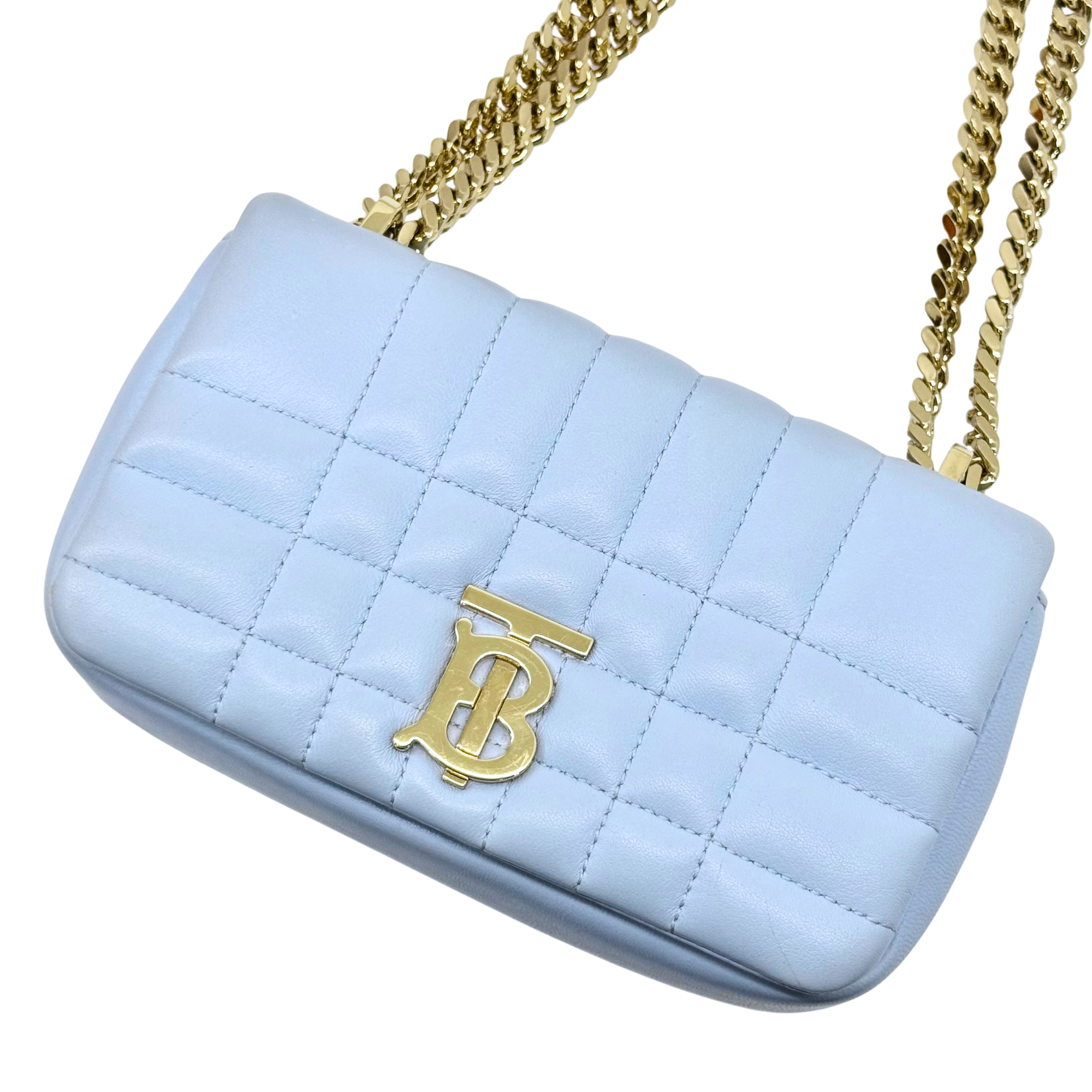 Light blue quilted shoulder bag with gold chain strap and gold B emblem front.