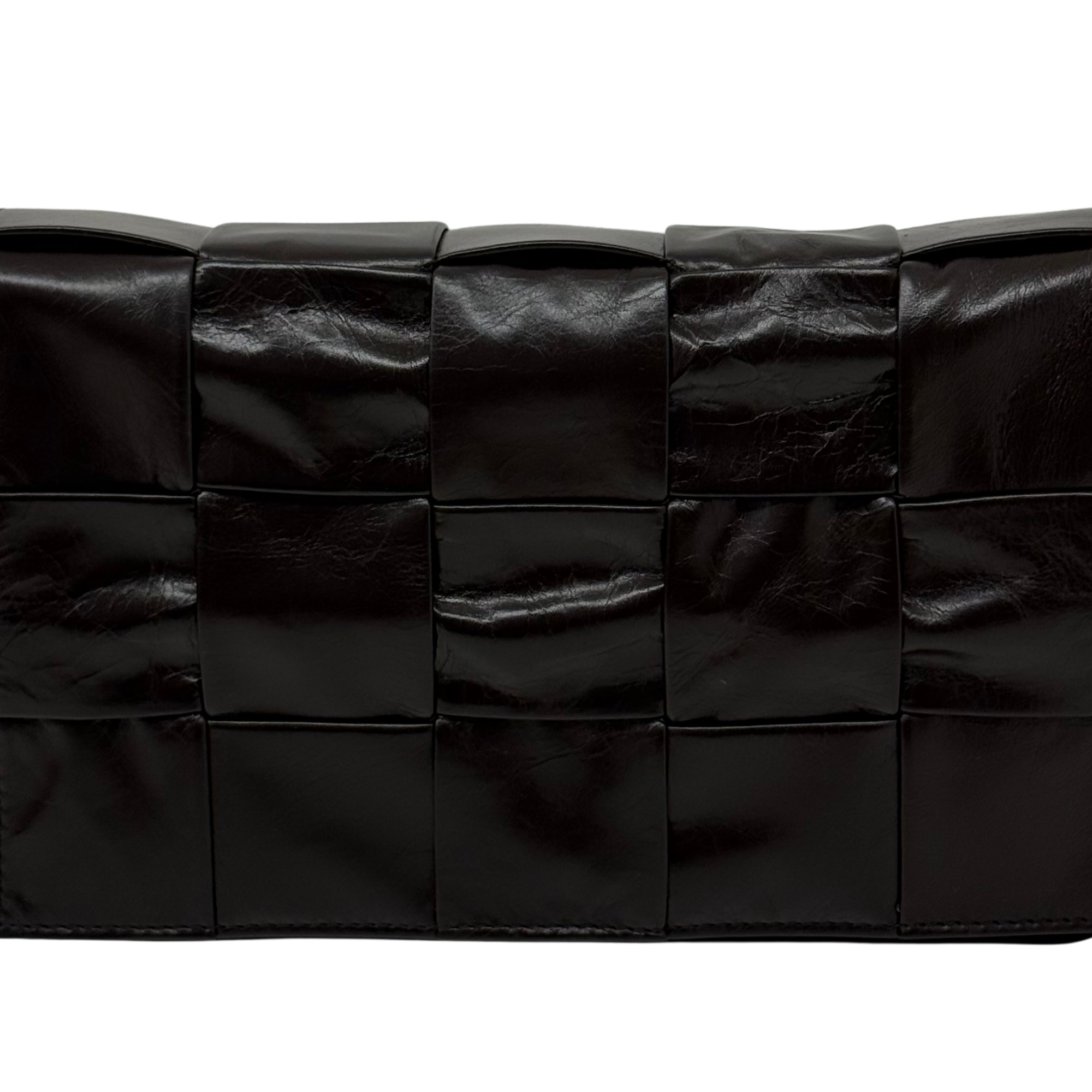 Black quilted leather bag with grid panel design and smooth padded texture