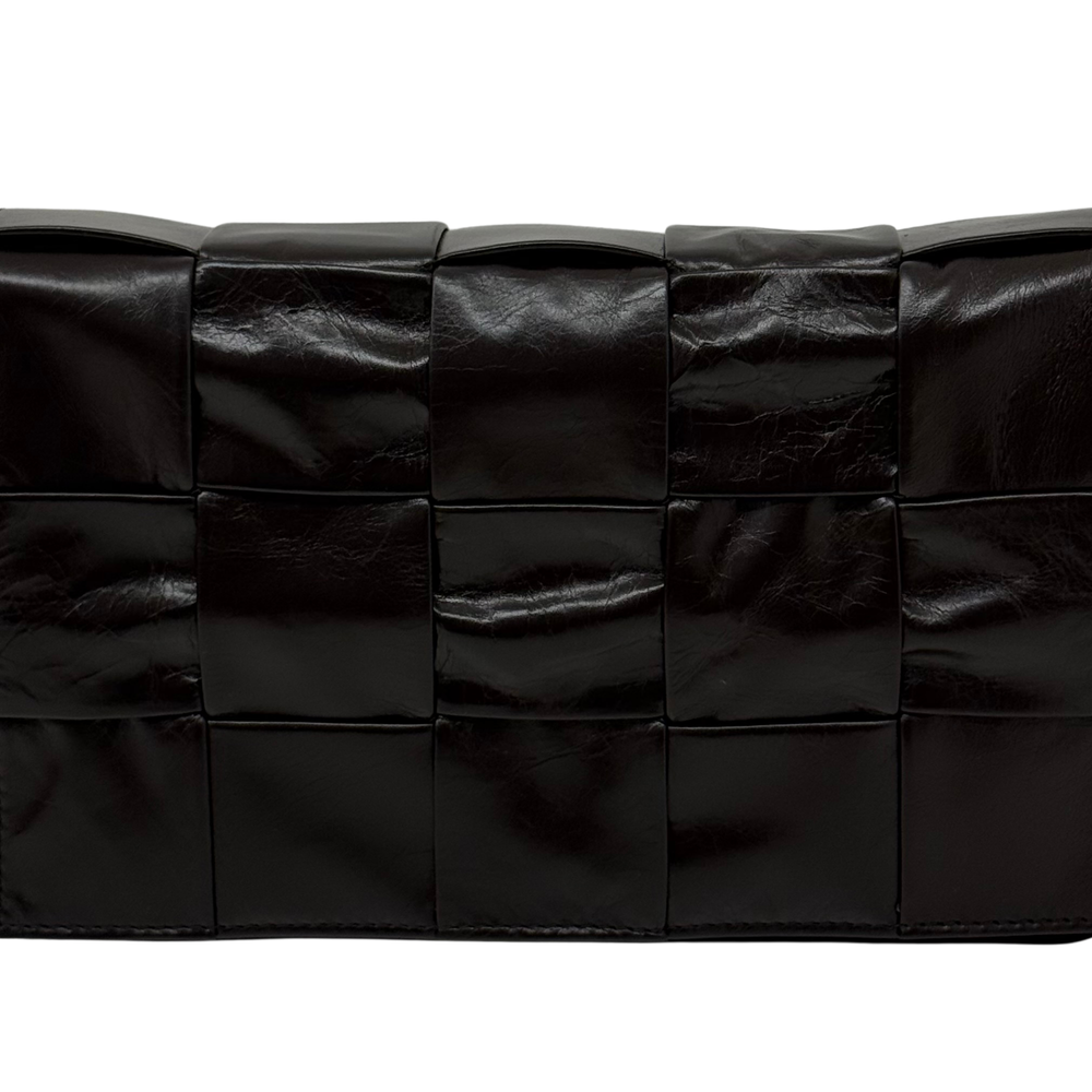 Black quilted leather bag with grid panel design and smooth padded texture