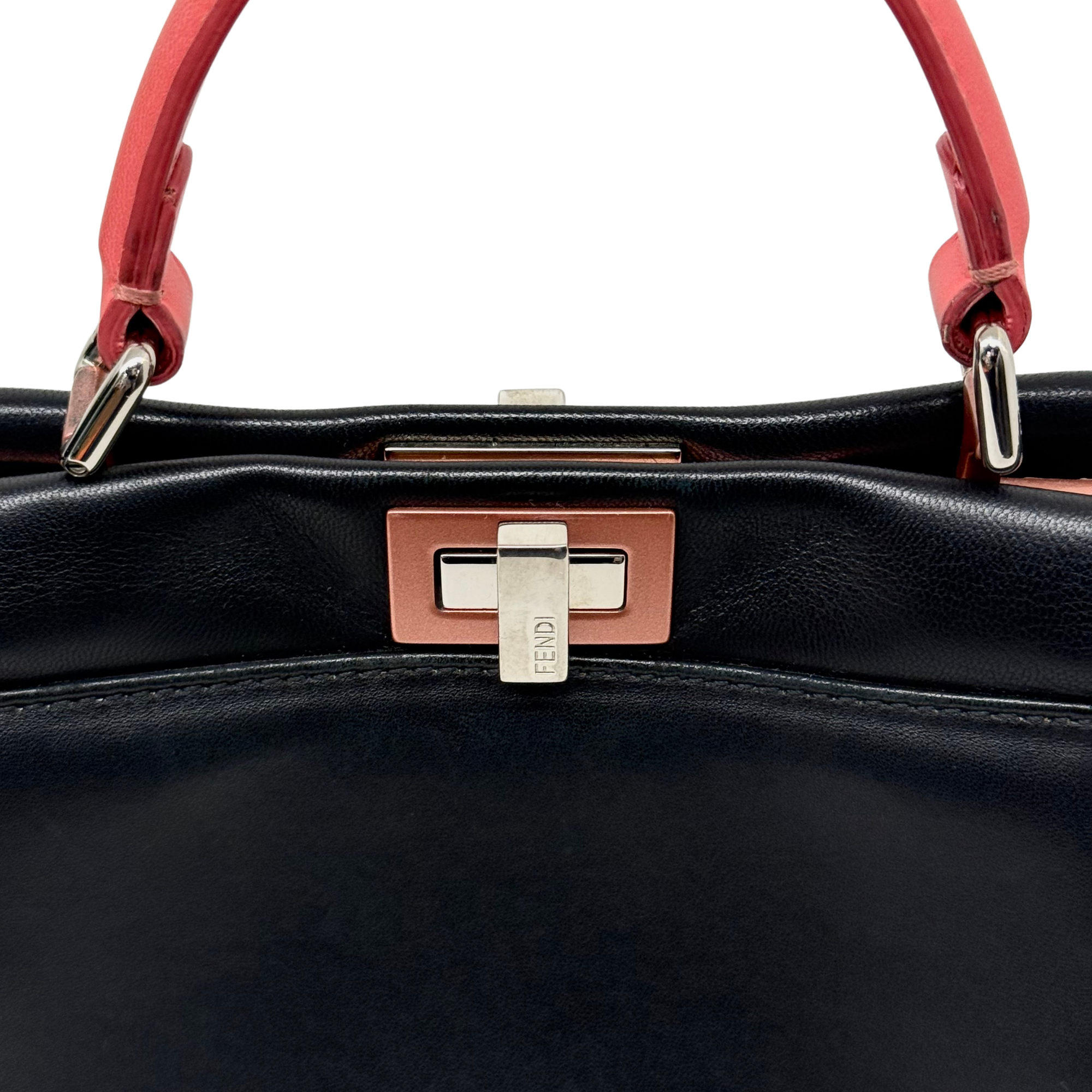 Front lock hardware with FENDI tag and red handles on black handbag