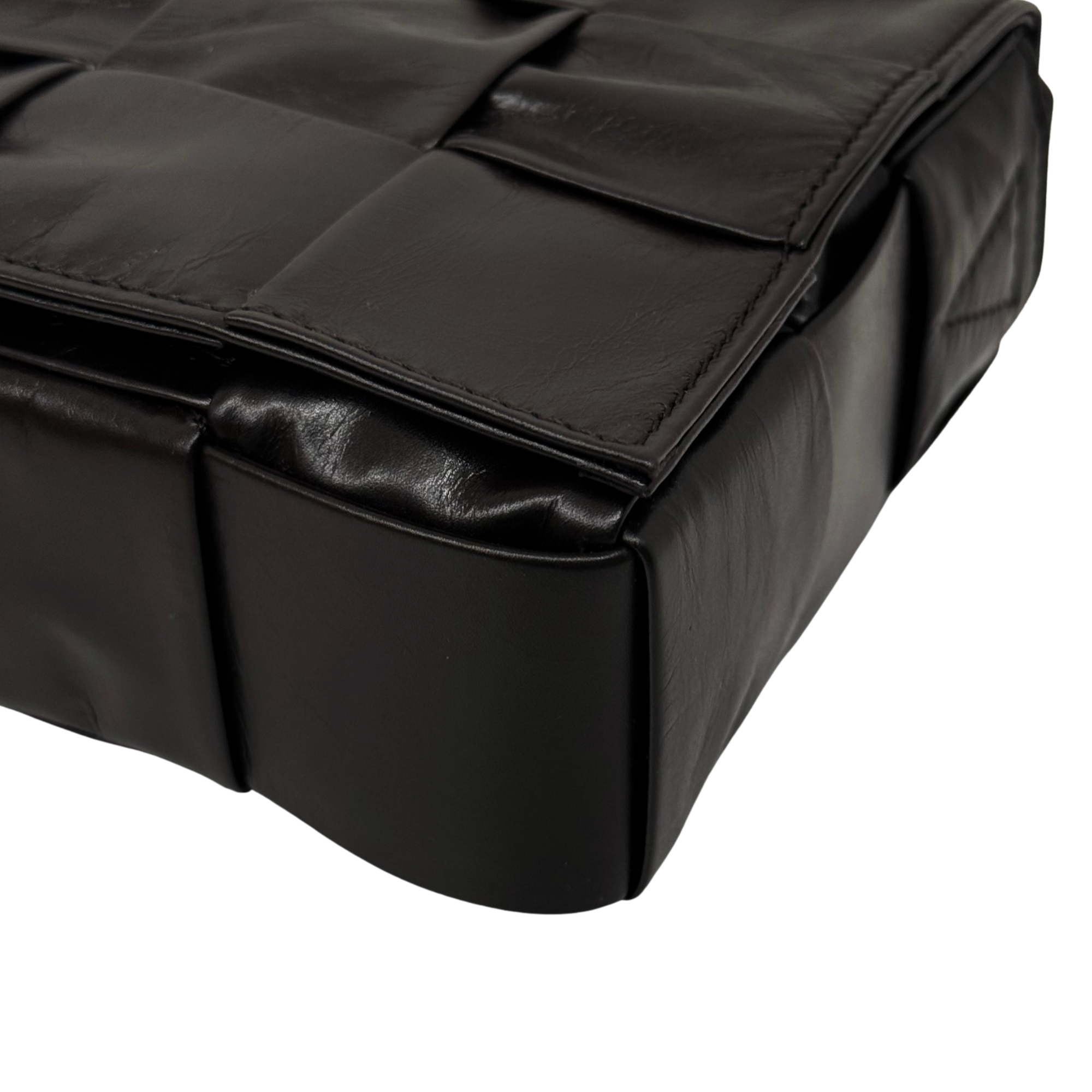 Quilted dark leather bag with top flap and rounded corner edging