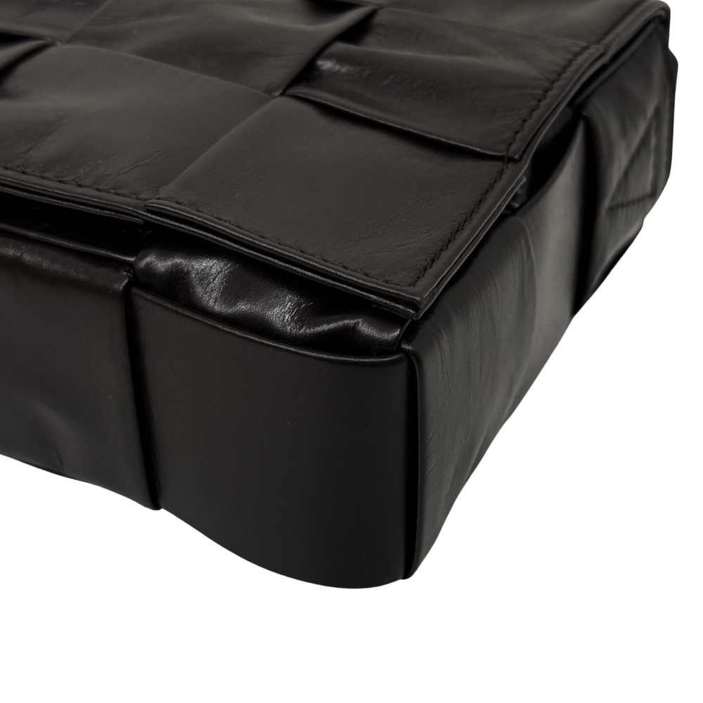 Quilted dark leather bag with top flap and rounded corner edging