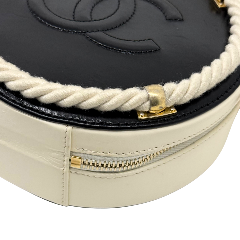 Close-up of cream bag front seam with gold zipper and braided cord trim
