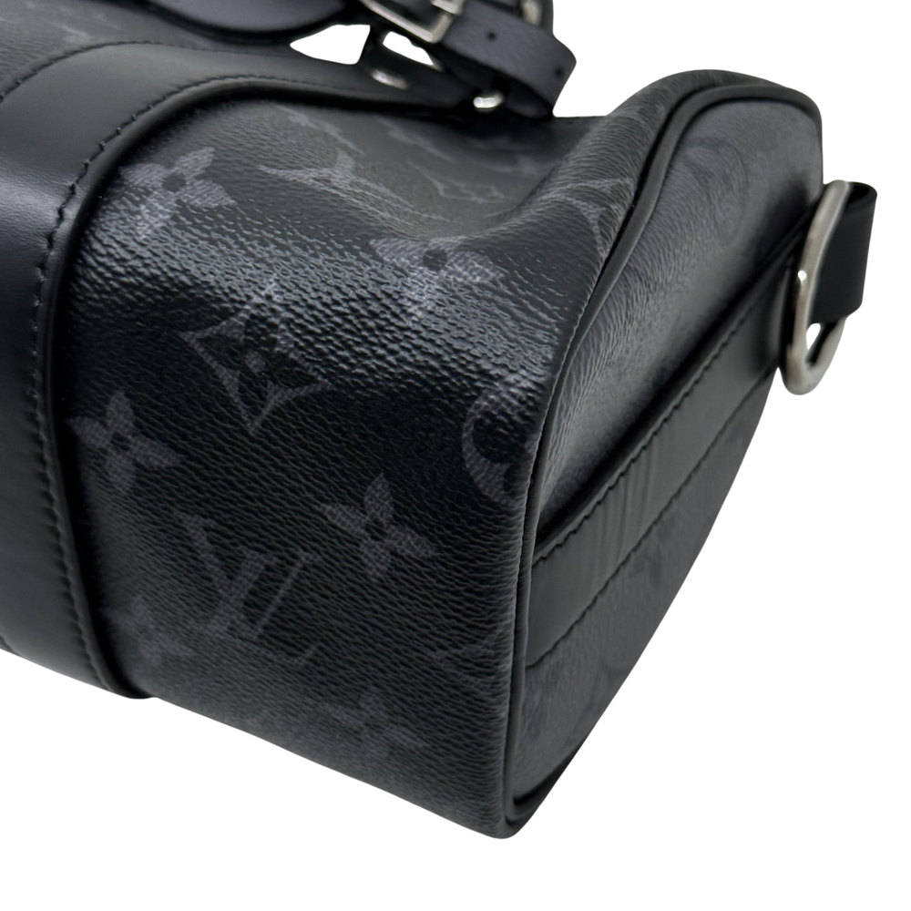 Black monogram handbag side with leather piping and top carry handle