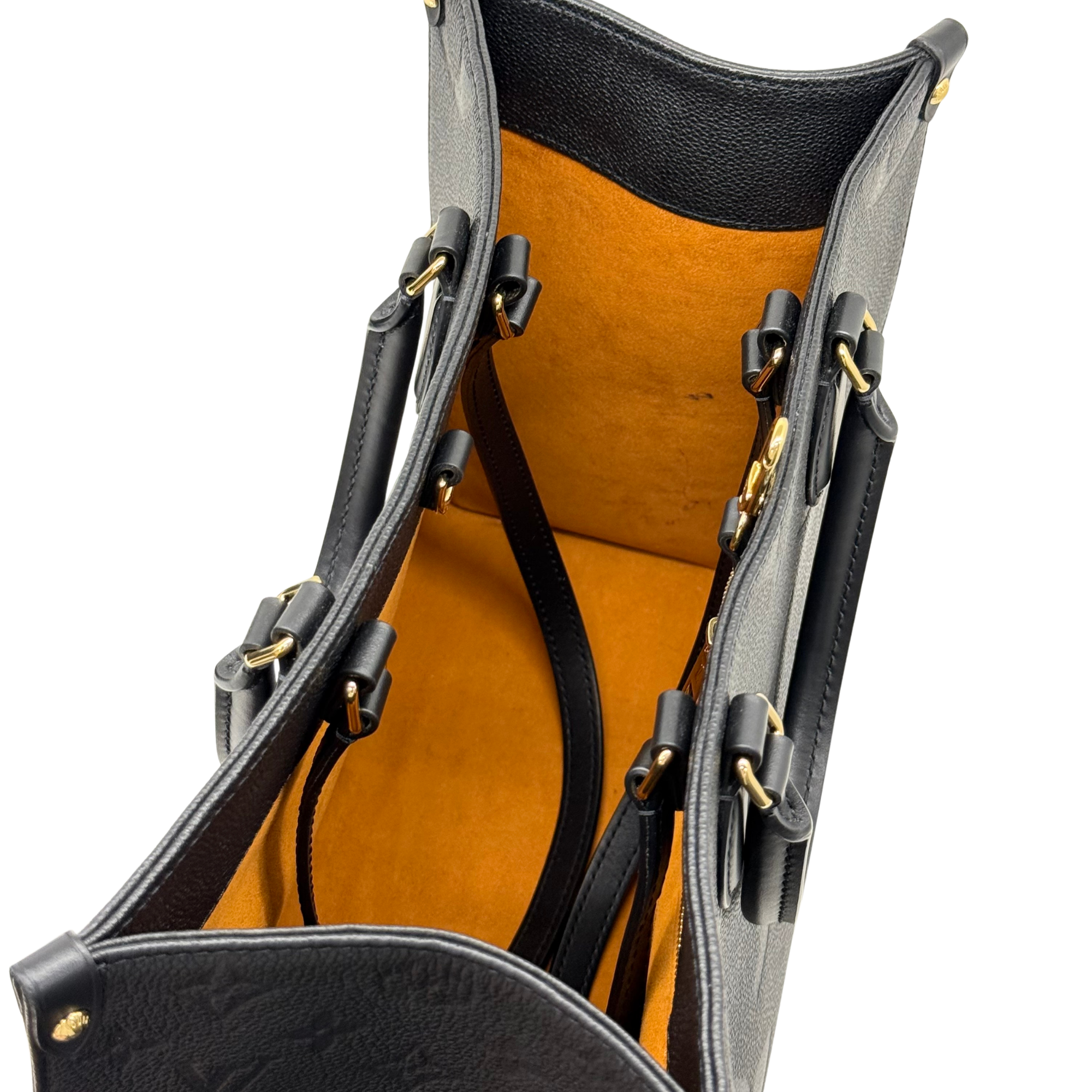 Louis Vuitton tote bag interior showing top opening, black straps, and tan lining